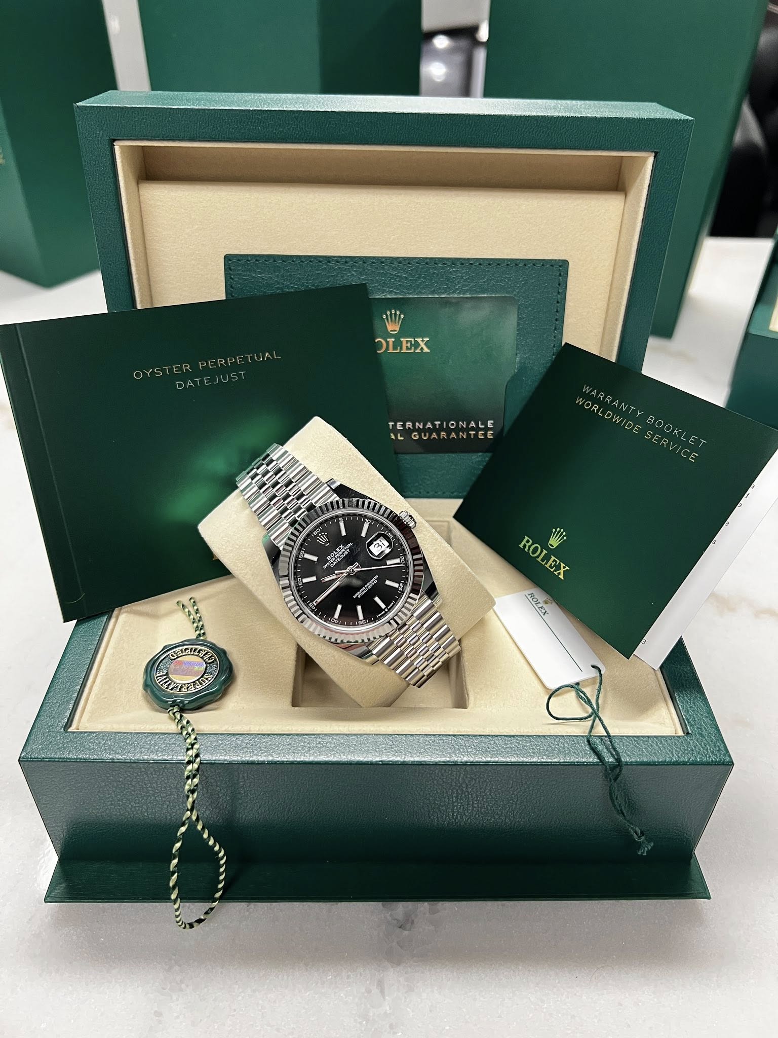 May be an image of wrist watch and text that says 'OLEX TERNATIONALE ONALE ILGUARANTER TE mu Cmo M M 福 遊 F I 日 S5 - gIA RO ROLEX i EX HOLEX APETERE'