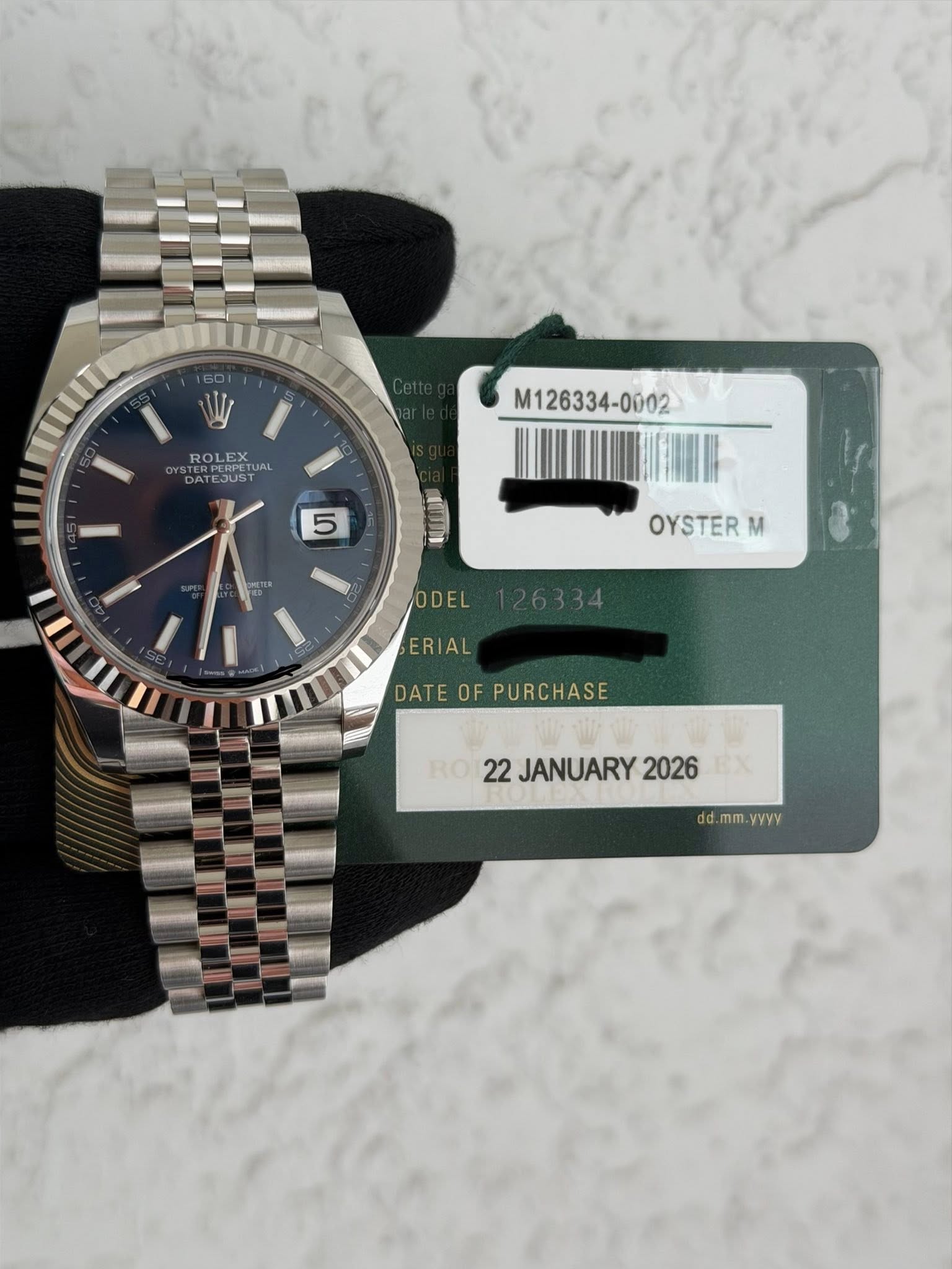 May be an image of wrist watch and text that says 'W ROLEX ROLEXUAL UAL DATEJUST M126334-0002 5 5 וגשר OYSTER M II ODEL ERIAL DATE DATEOFPURCHASE OF PURCHASE RO 22 JANUARY 2026…