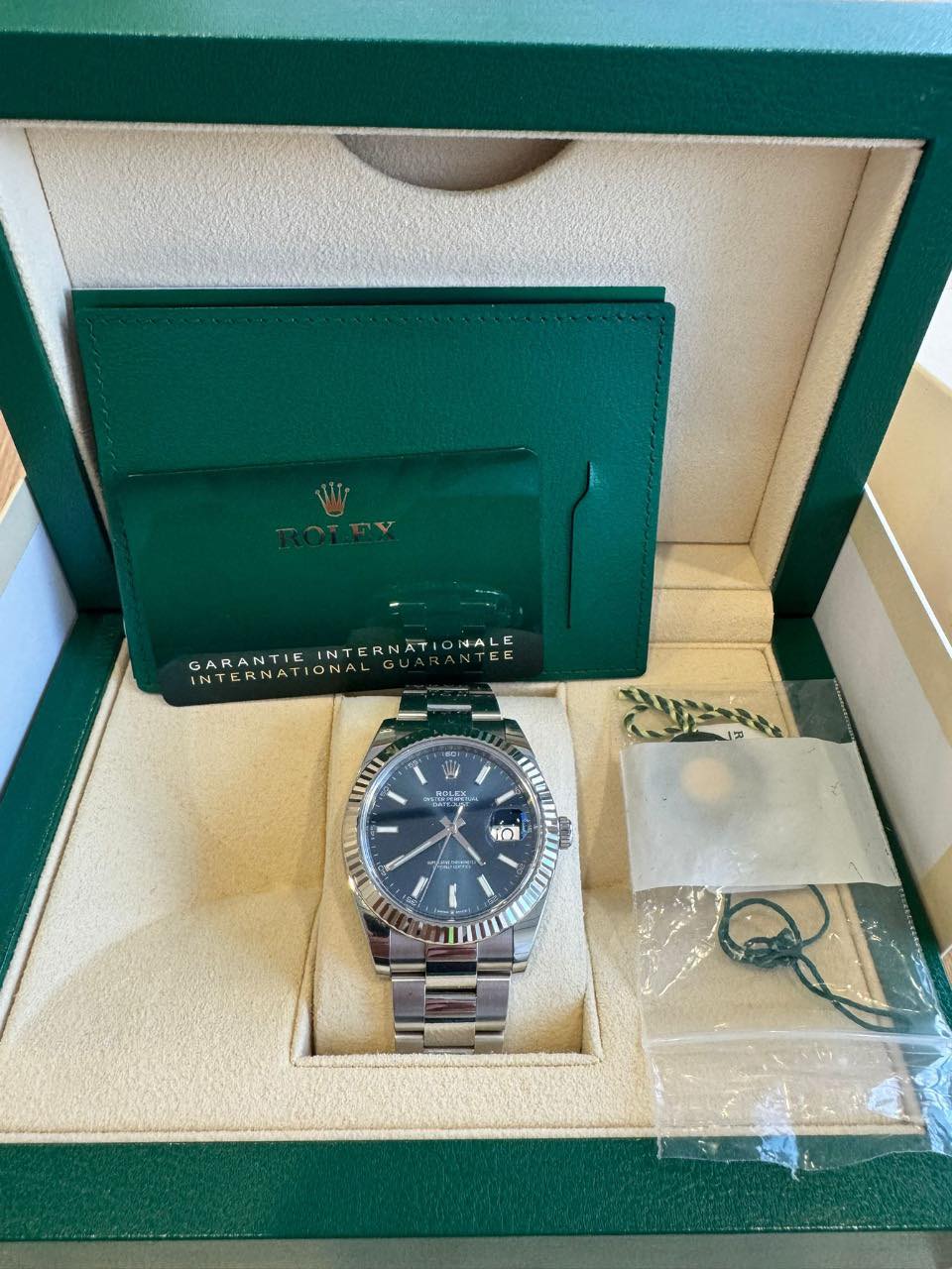 May be an image of wrist watch and text that says 'INTERNAT INTERNATIONALE NALE 4 GARANTIE TEE E E INTERNATIONAL INTERNATI ONAL UITI 밥 코목는트 HOLEK I ወ OI'