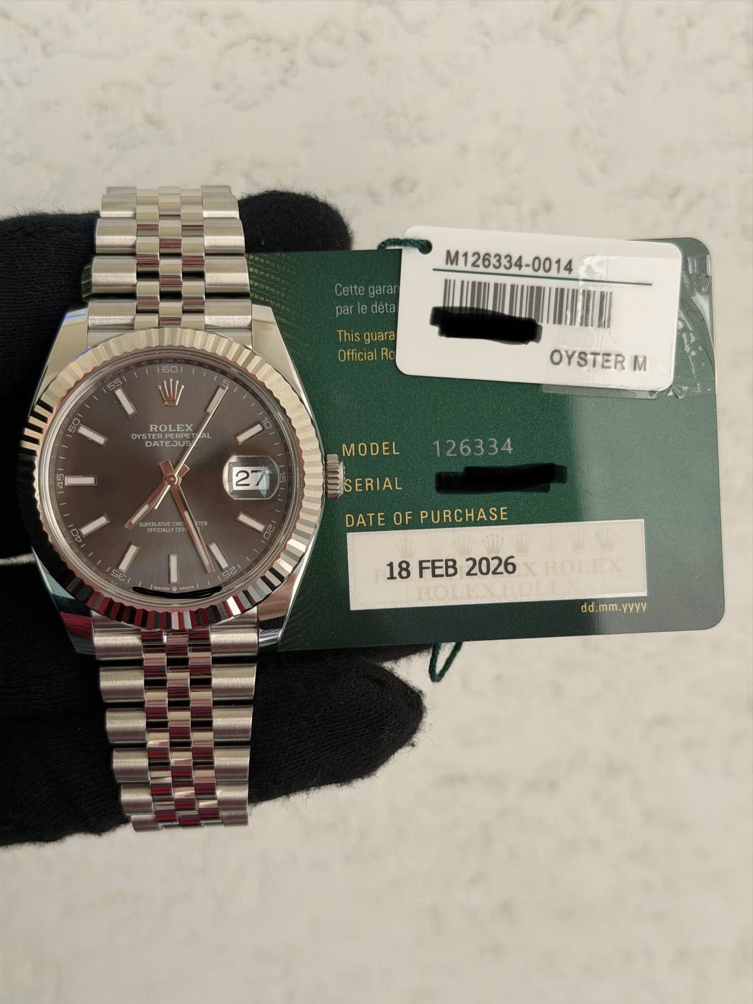 May be an image of wrist watch and text that says 'Celtegaran M126334-0014 Thisguara OfficialR 601 W ROL ROLEX EX ROL EX DATEJU ATCOUE PET TERIA OYSTER M MODEL ESERIAL DATE…