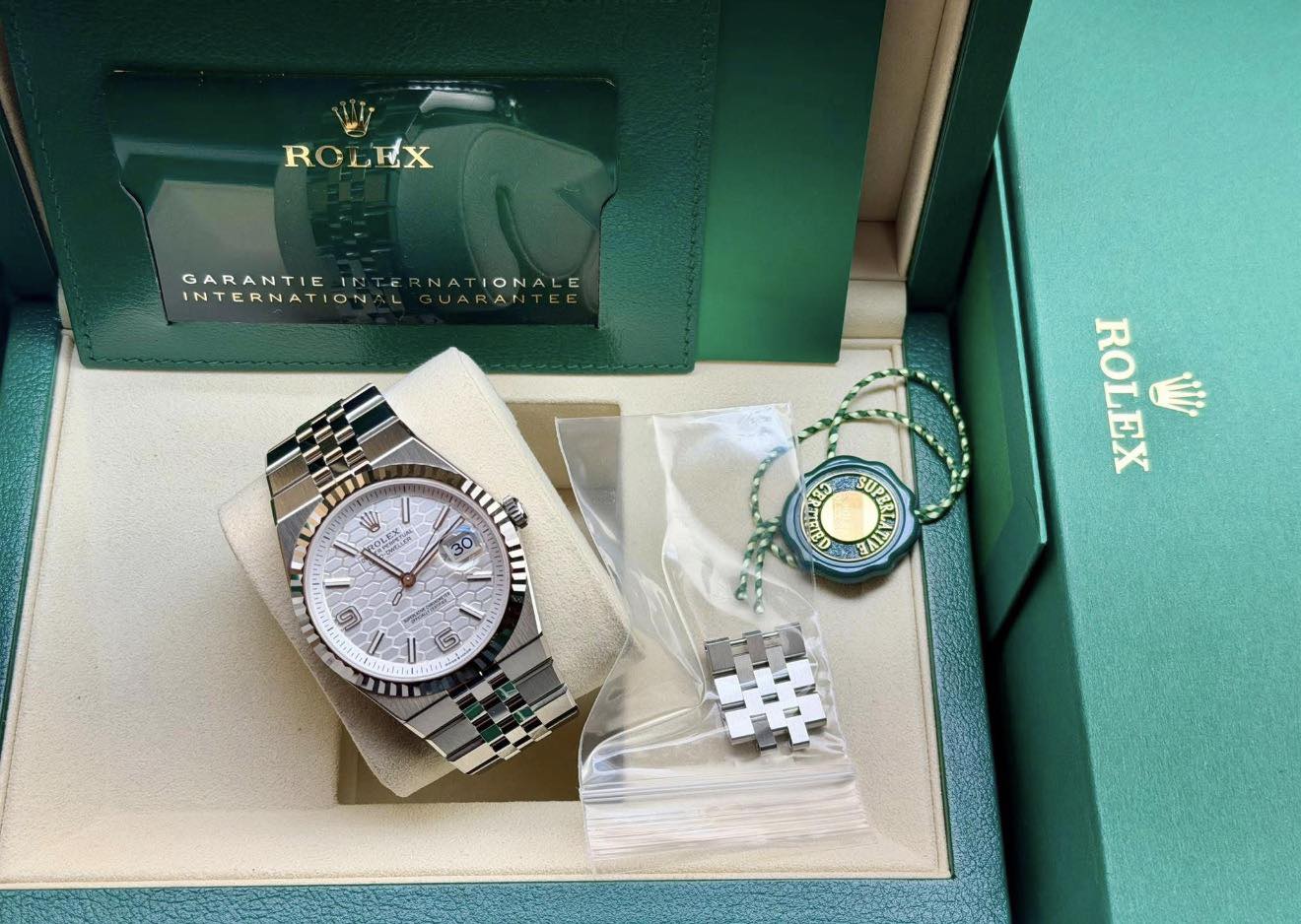 May be an image of wrist watch and text that says 'ROLEX GARANTIEINTERNATIONALE GARANTIEINTER GARANTIE NATIONALE INTERNATION UARANT 业 11 ttg AAR 3 O O 0 0 ROLEX ا١ L0 T'
