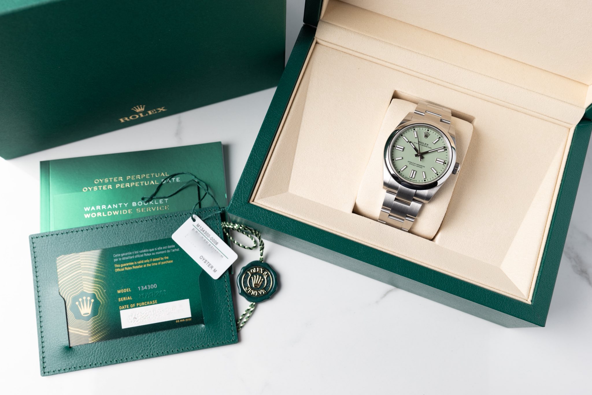 May be an image of wrist watch and text that says 'OYSTER PERPETUAL OYSTER PERPETUAL OYSTERPERPETUAL OYSTERPERPETUAL'RTE ATE WARRANTY BOUKLET WORLDWIDE WARRANTYBOUKLET SERVICK 7…