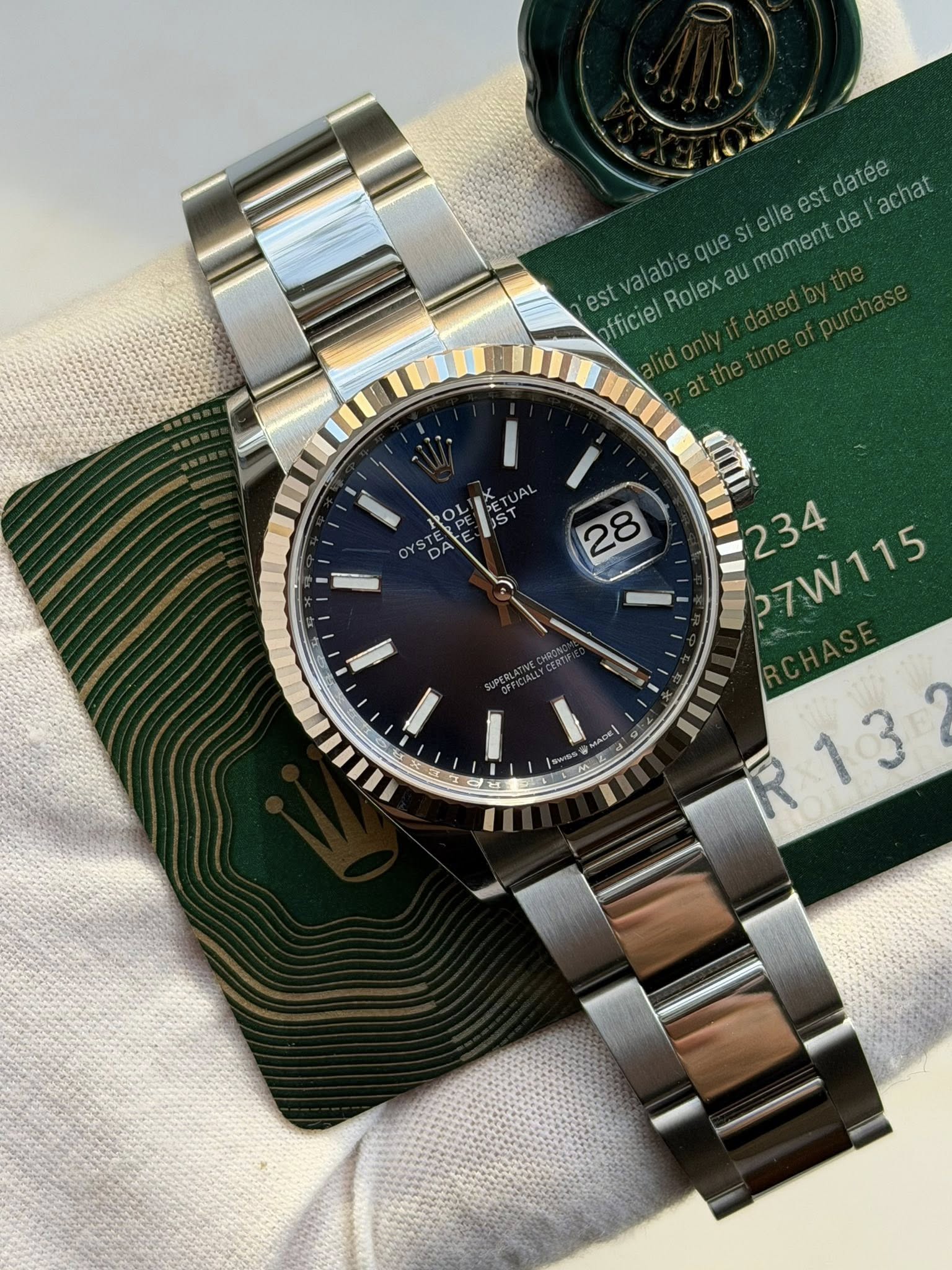 May be an image of wrist watch and text that says 'est datee l'achat elle que moment de est a Rolex au fficiel 28 ரம் P7W115 P7W115 234 "/P R13 mu'