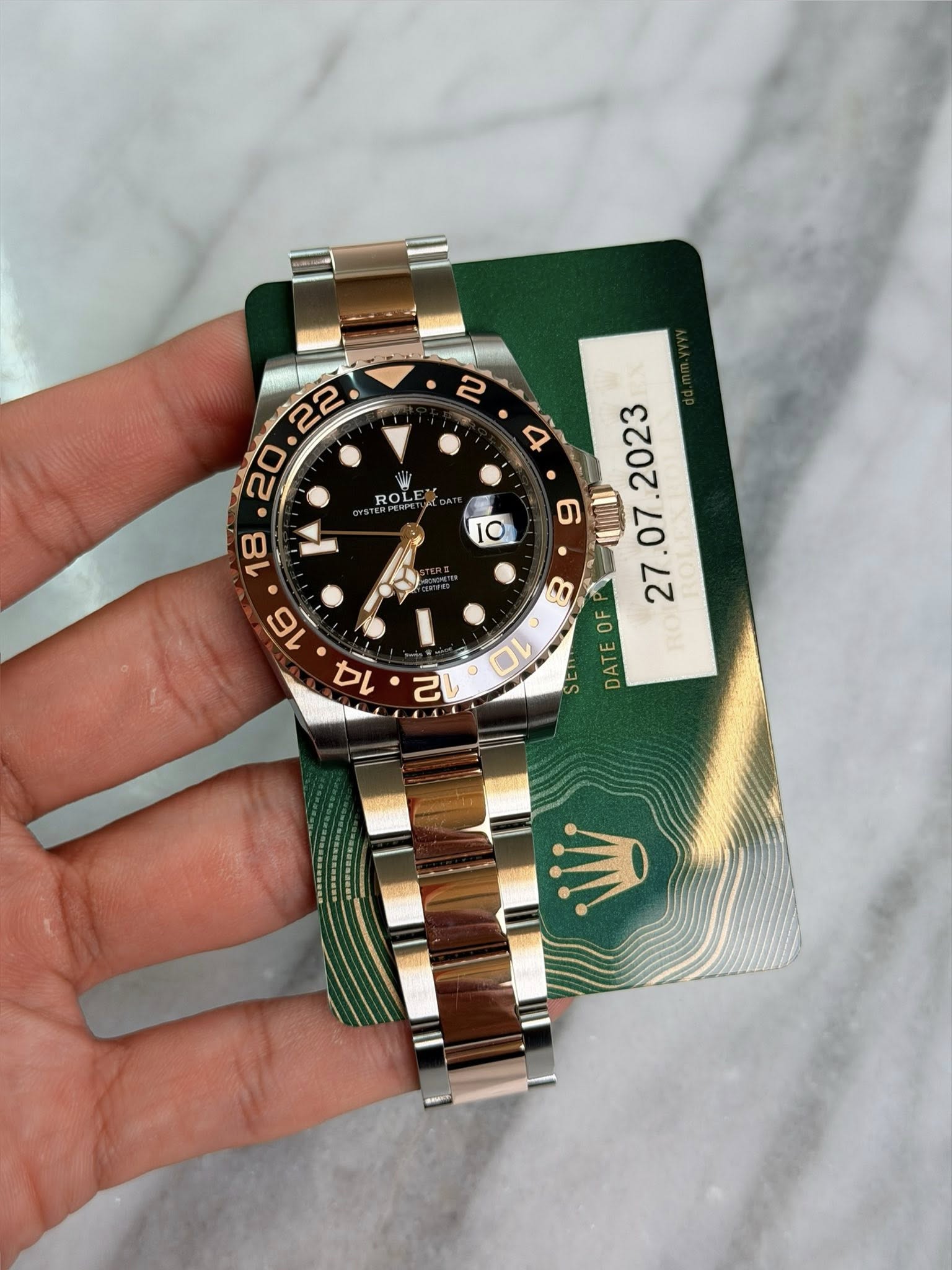 May be an image of wrist watch and text that says '2 C OA 20.22 ROL ROL மு OF DATE 0 12'