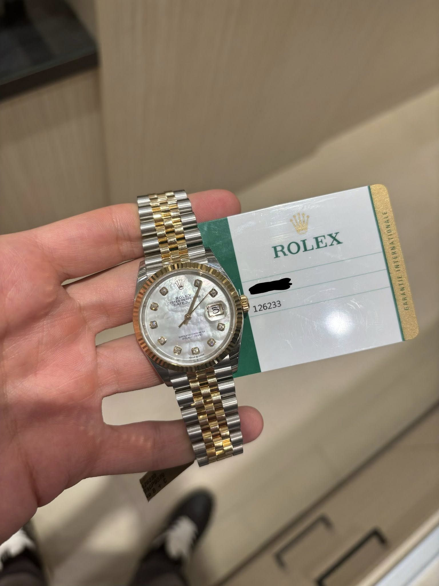 May be an image of wrist watch and text that says 'ROLEX NDATE ู 地 粒 Ε 126233 ® む'