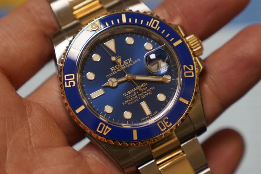 May be an image of wrist watch and text that says '10 動力 ROLEX ROLEX 09 20 SUBMAR I 00 3'