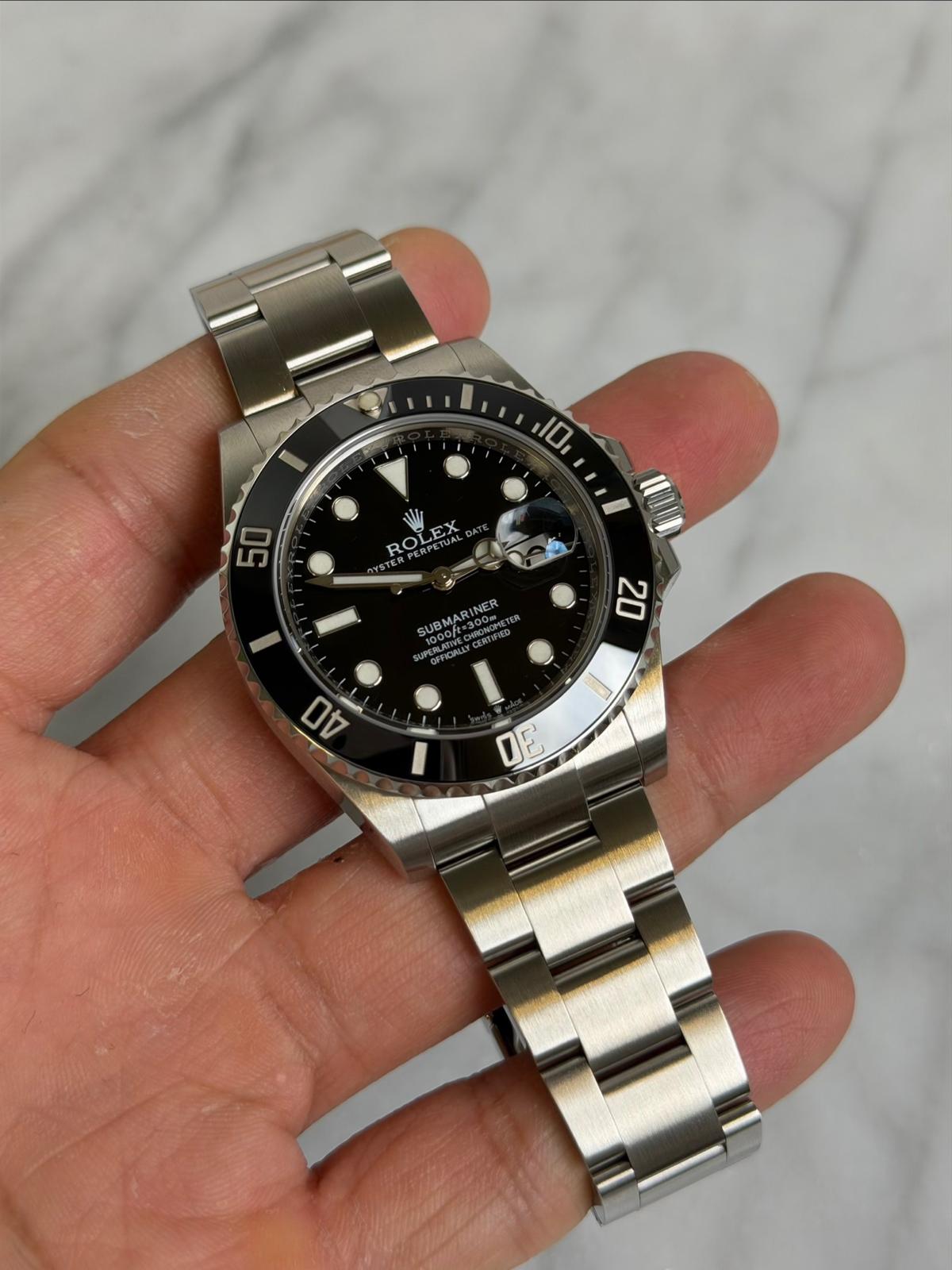 May be an image of wrist watch and text that says '10 50 ROL ROLEX SUBMARINER INER SUBMAR UPENLATI OFFICIALLT OEEA 20 DD DE'