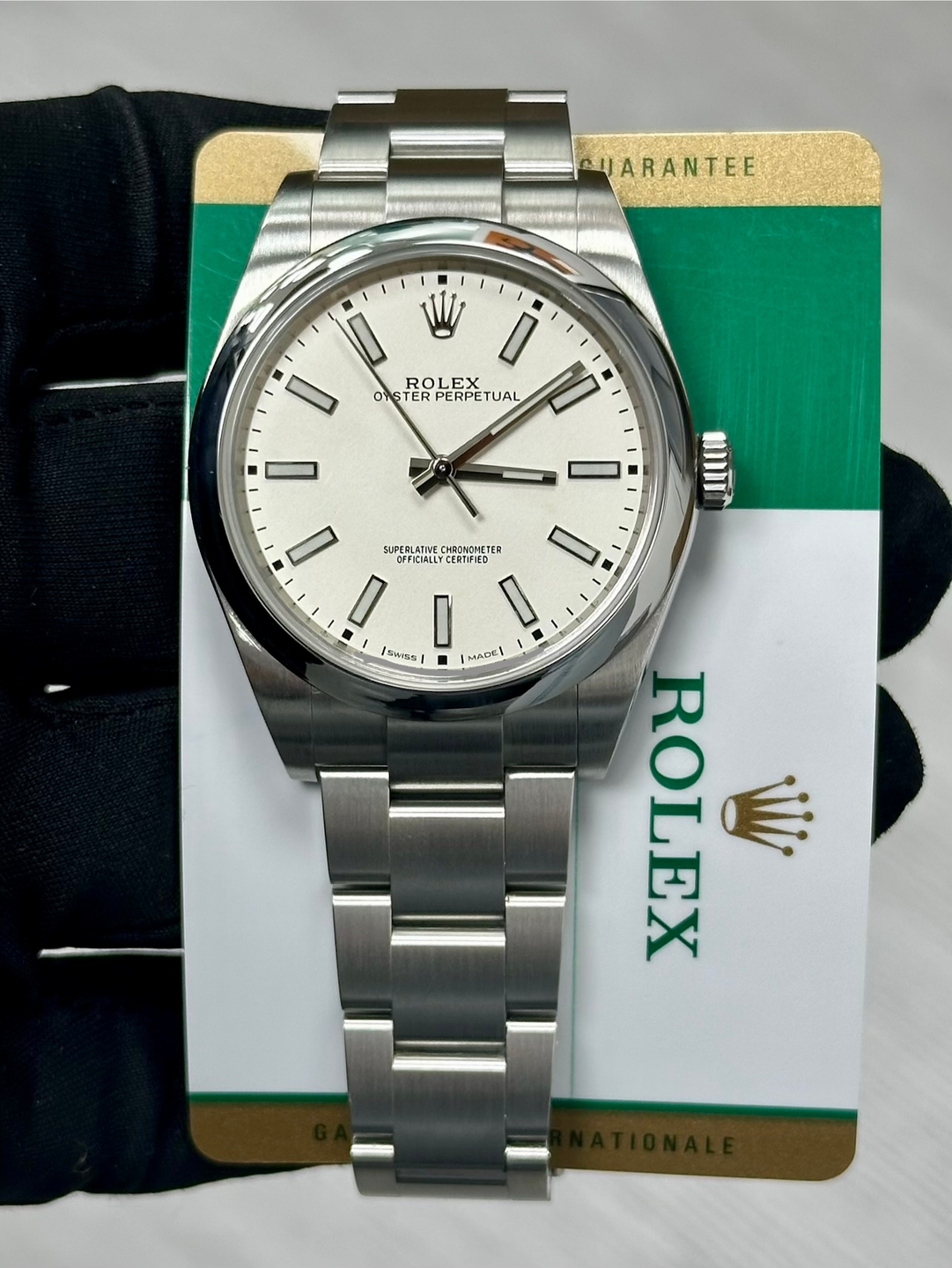 May be an image of wrist watch and text that says 'CHARANTEE 製 W I ROLEX LEX OASTER ASTERPERPETUAL PERPETUAL PERPE TUAL 0 I BTT SUPERLATIVE OFFICIALLYCER CERTIFIED RJNDHETER SL TER…
