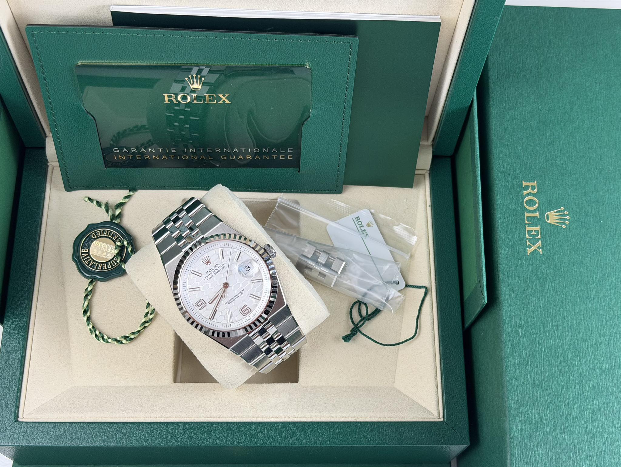 May be an image of wrist watch and text that says 'ROLEX GARANTICINTERNATIONALE NT ARANTIC RNATION UAR BLLYA TY 가랑베레L U L ROL 客 W GLAO က C श ROLEX Wi'
