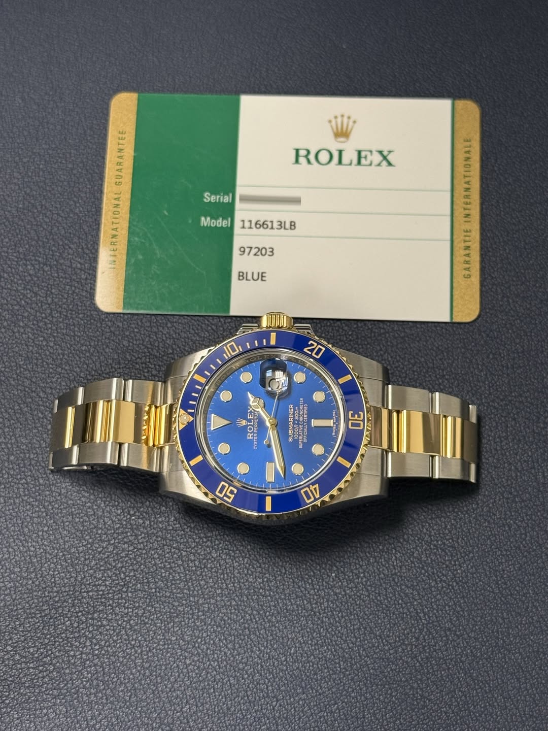 May be an image of wrist watch and text that says 'Serial ROLEX GUARANTEE INTERNATIONAL Model Model116613LB 116613LB 97203 BLUE GARANTIE 10, 20 I AлИ EBKиeлb R ዕዋን BOл ROLRY…
