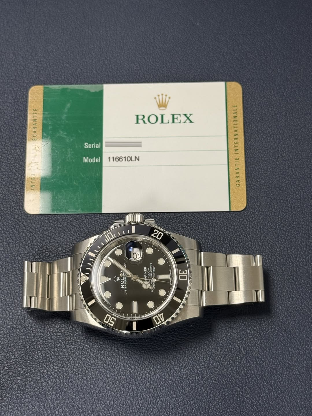 May be an image of wrist watch and text that says 'A ROLEX Serial Model116610LN Model 116610LN 10 20 三 S '