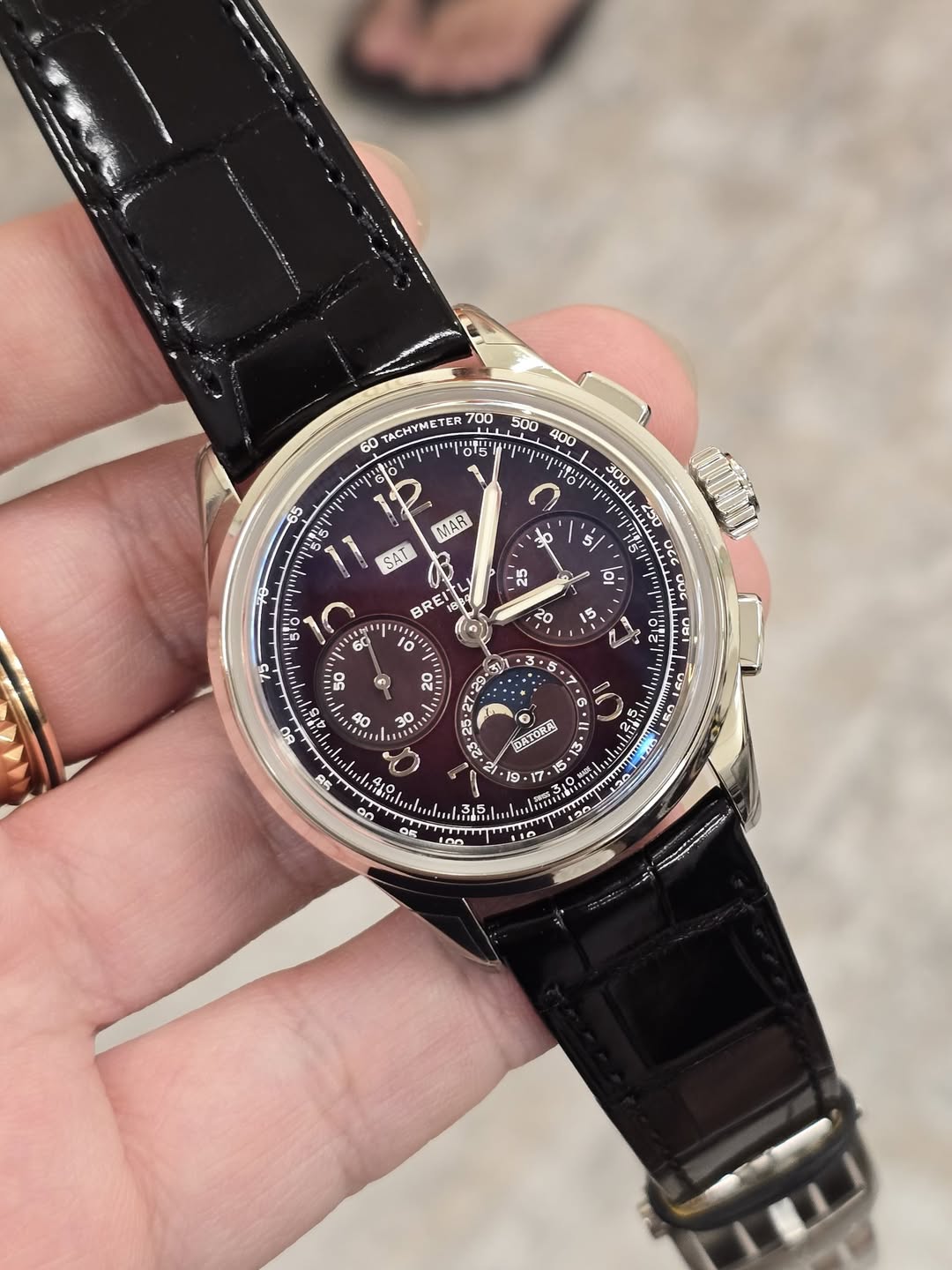 May be an image of wrist watch and text that says ' TACHYMETER ምሬንድል 015 400 e 1 酒洁自な 300 1230 ら 0 65 siS MAR 3o SAT BREI ס' 5 50 ก 5 ויויויו 22 30 O د お 発 an BATOAA! 9.'