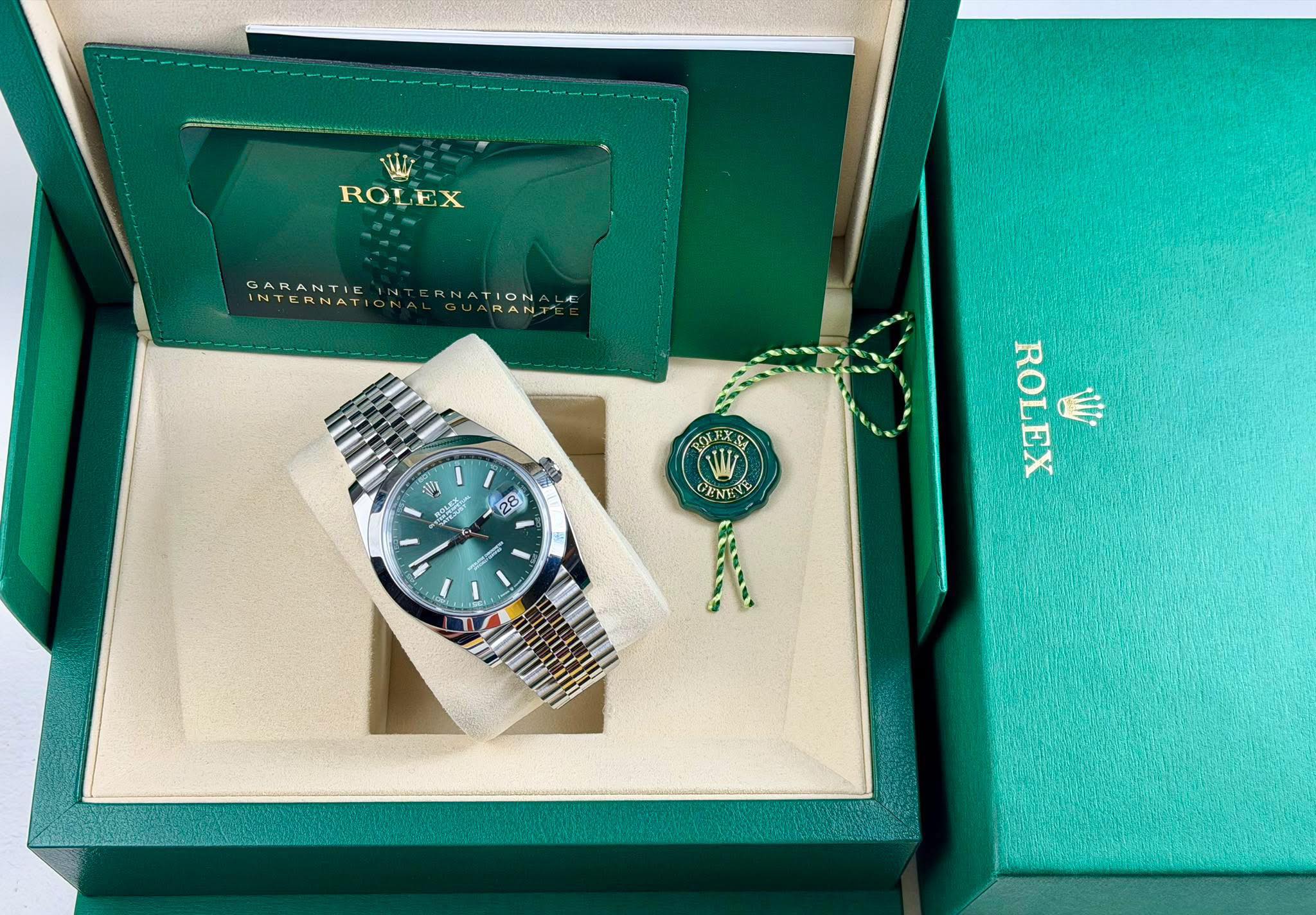 May be an image of jewelry, wrist watch and text that says 'RO ROLEX GARANTIE GARANTIEINTERNATIONAL ERNATION IN 3O 1 S V yTa 28 O CINE ROLEX W'