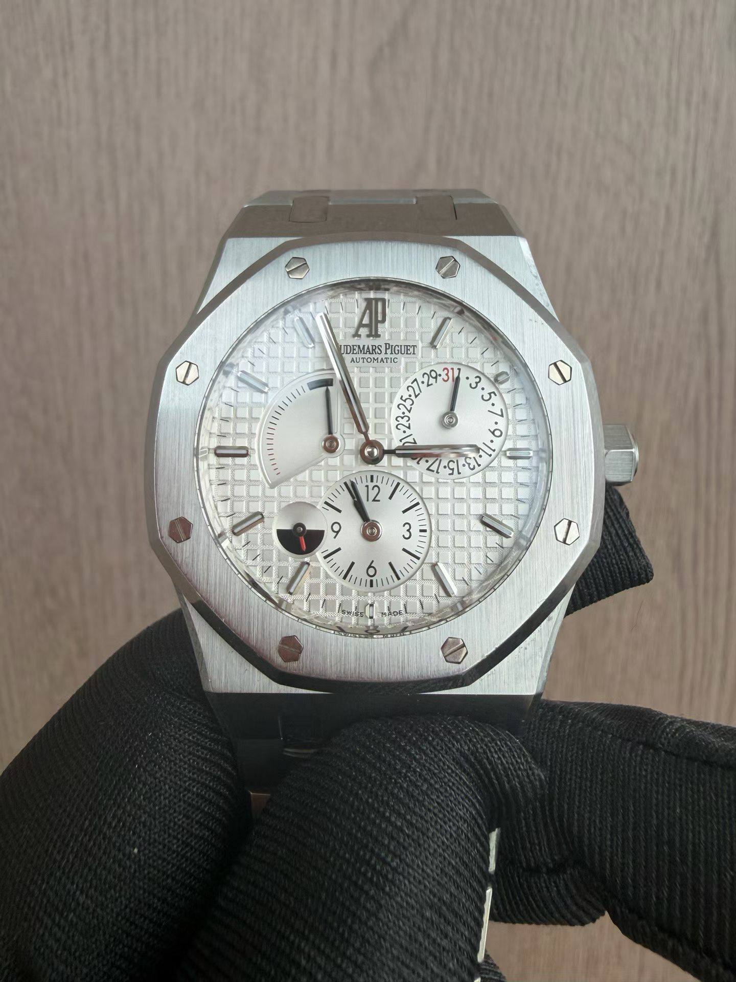May be an image of wrist watch and text that says '1E1TIa A UDEMARS PIGUET AUTONA AUTOMATI G 1. 9. 0 ي .5ι . 3 S8/1E 12 و1 1 ي 3 م T L ٩ =O'