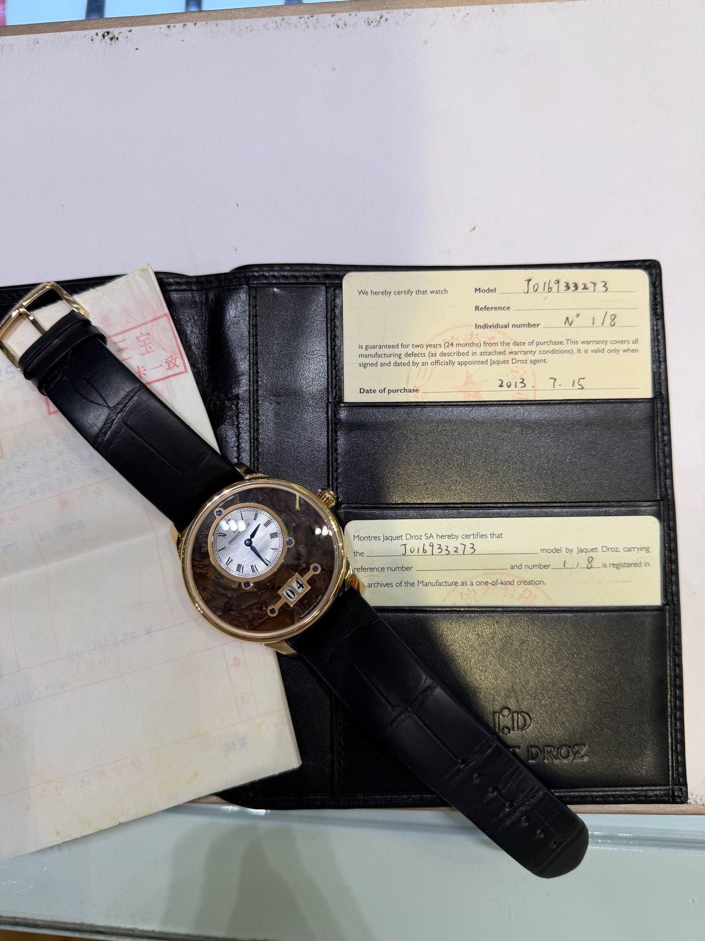 May be an image of leather wallet, leather, wrist watch and text
