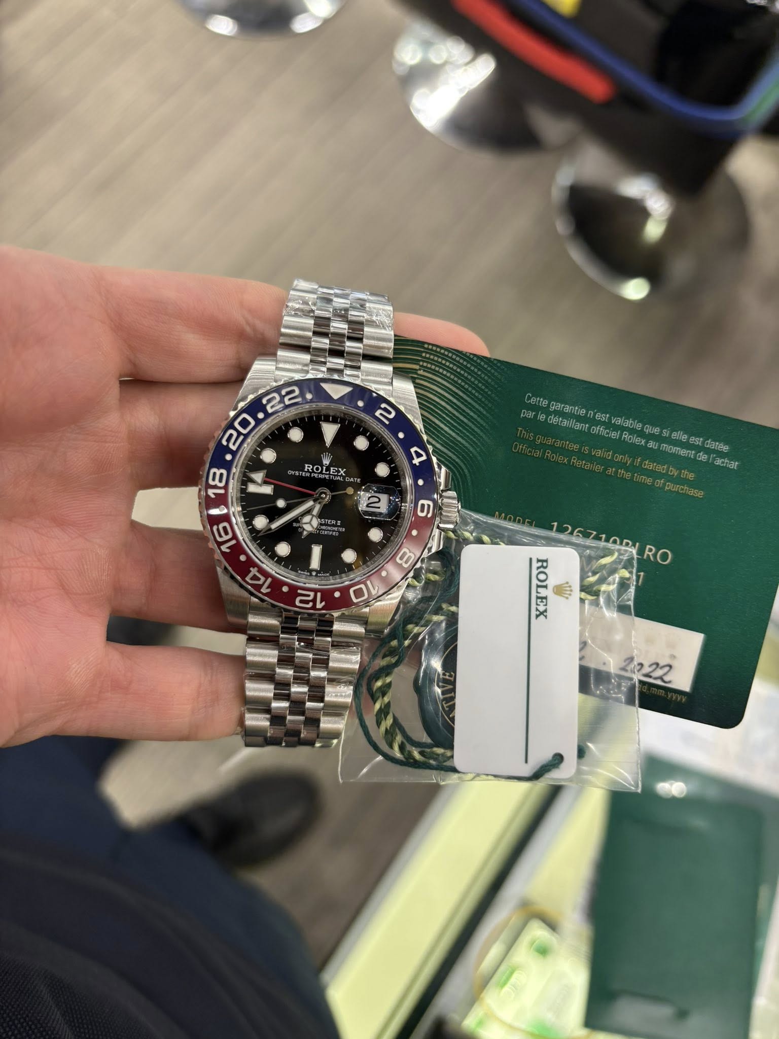 May be an image of wrist watch and text that says ' RO LEX 16 14 ettegarantie estvalable GrticielRolexau momentd datte achar 2 S 126710D1 ROLEX 1 RO 2022'