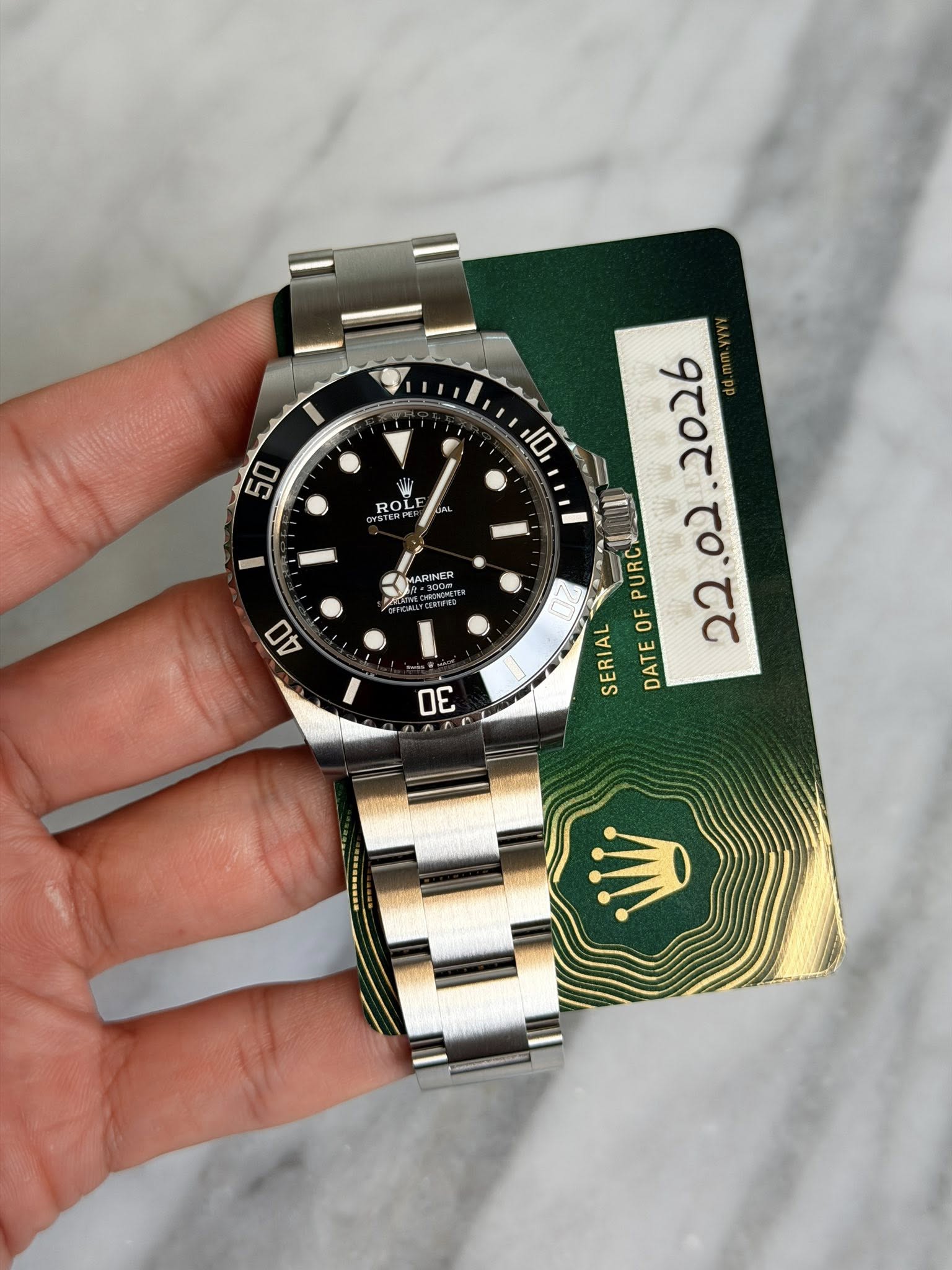May be an image of wrist watch and text that says '50 10 ROL MARINER o2 PURC OF SERIAL イ 0 22 0 DATE OE'