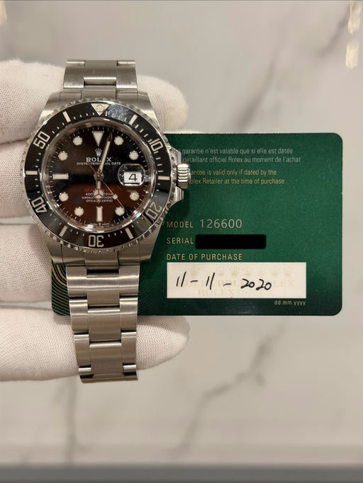 May be an image of wrist watch and text that says '50 ROL 0E URCHASE ニー二 1/-1/- '