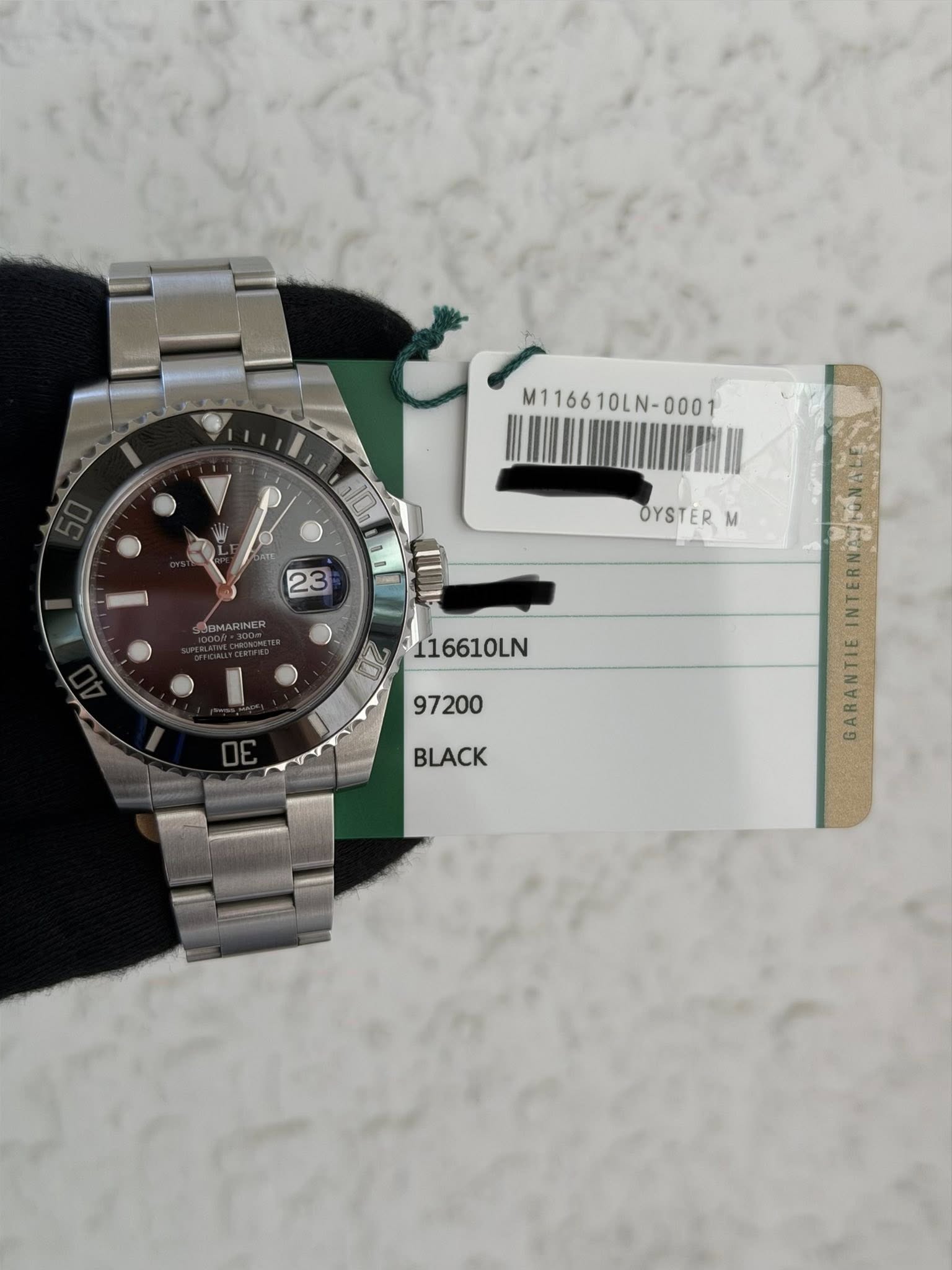 May be an image of wrist watch and text that says 'M116610LN- ABMARINER 116610LN 97200 OYSTER M Am GARANTIE BLACK'