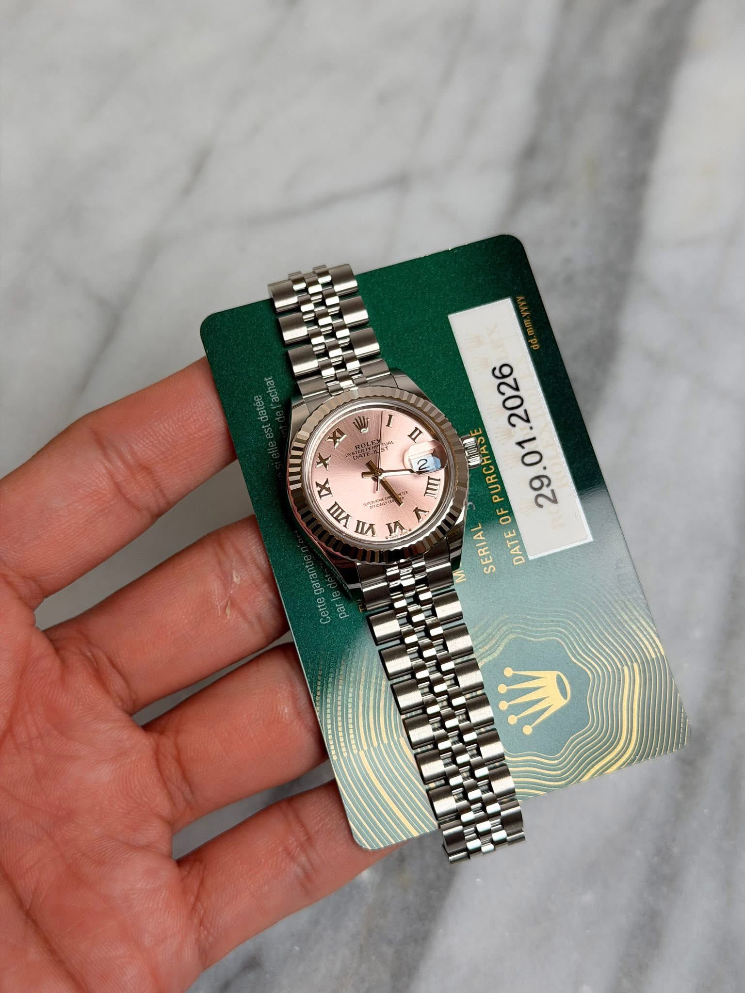 May be an image of wrist watch and text that says 'I ห้ muR + ME XI IX I 百 yW nA 1 2026 2 IIU PURCHA OF 29.01 SERIAL DATE ၆၁၁၁၅ อ.อว MI'