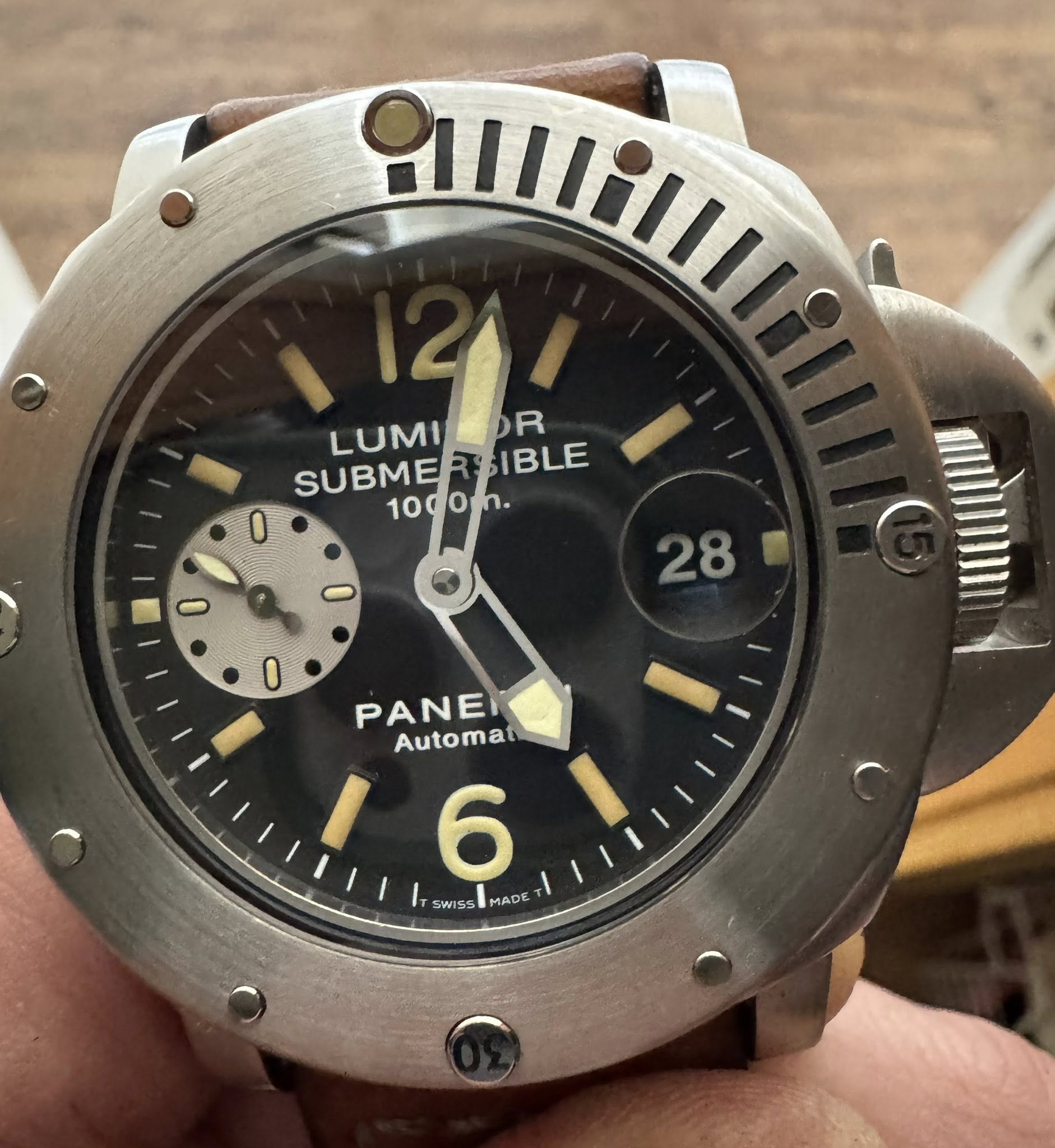 May be an image of wrist watch and text that says 'Km LUMILOR R LUMI SUBMERSIBLE 1- SUBME IBLE 10d0mh. 10 لء 28 O PANEI Automat 6 TSWISS AD'