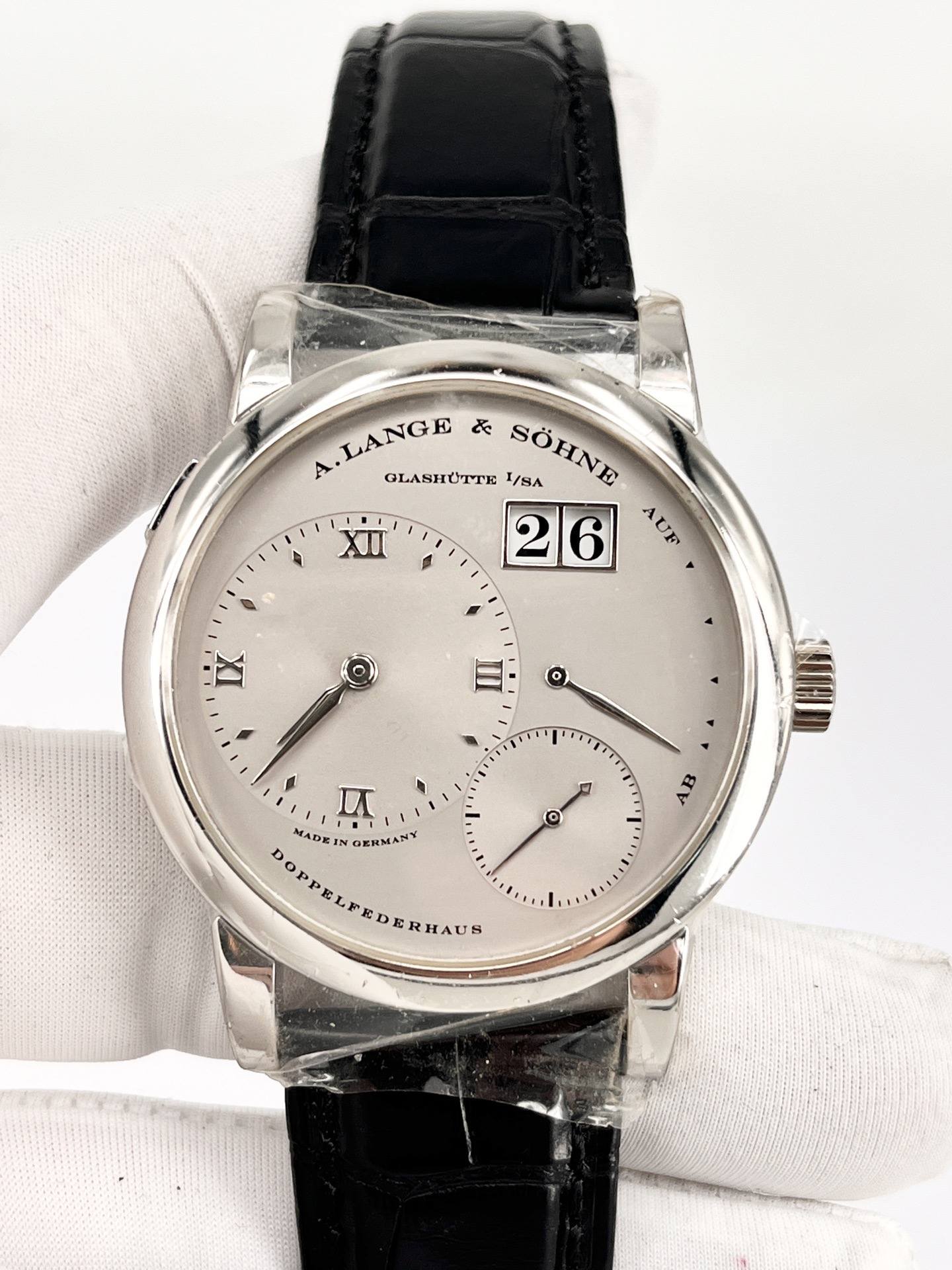 May be an image of wrist watch and text that says 'LANGE LANGE ど A. лRHOTTE SÖHNE I/SA 26 AUF IX 包 4 O II DOPPELFEDERHAUR MADE MADEI GERMANT DERHAUR'