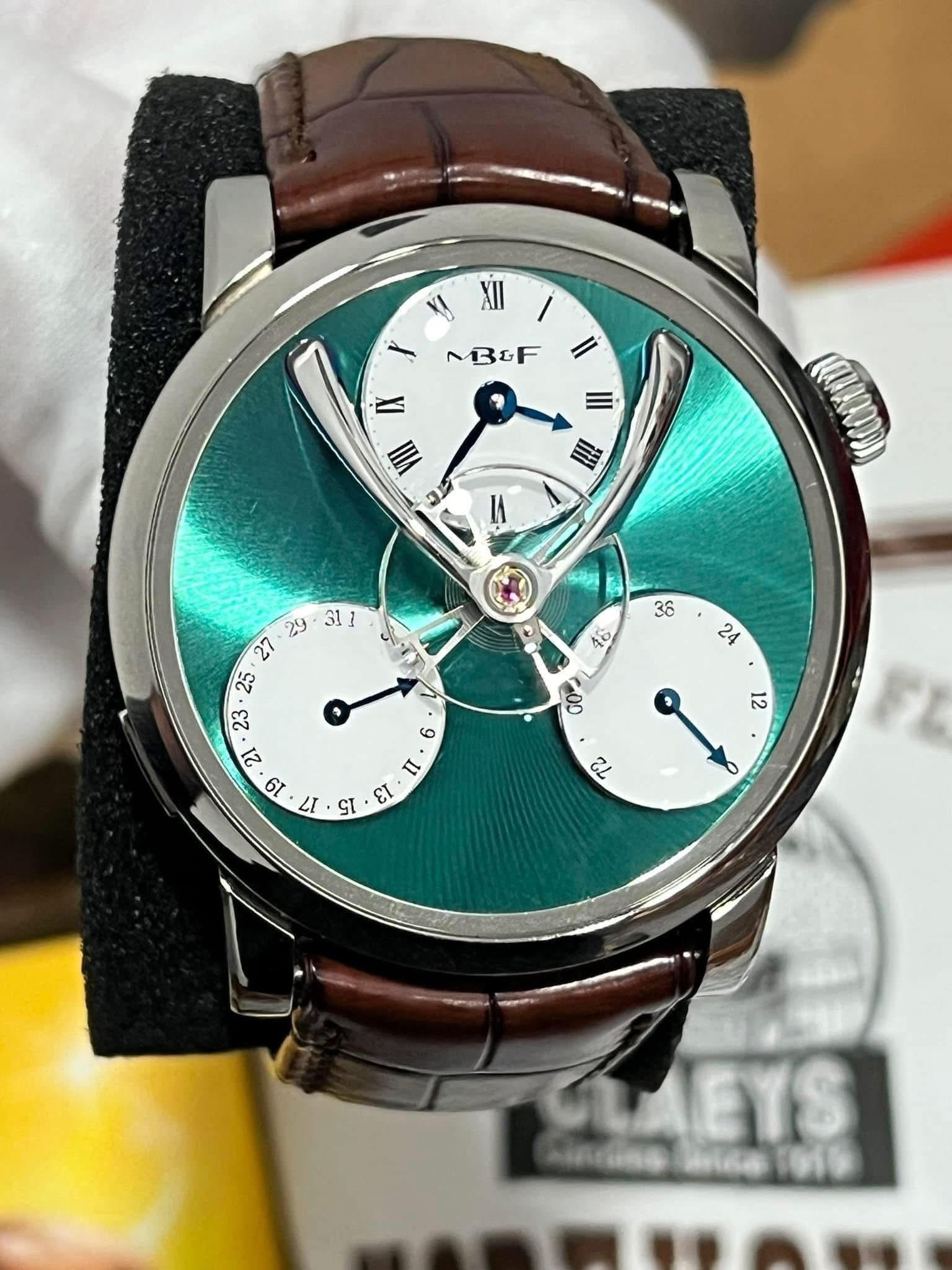 May be an image of wrist watch and text that says 'XII XII MBOF Il II VII II १ 4 S ει GO 21 ه LAEYS'