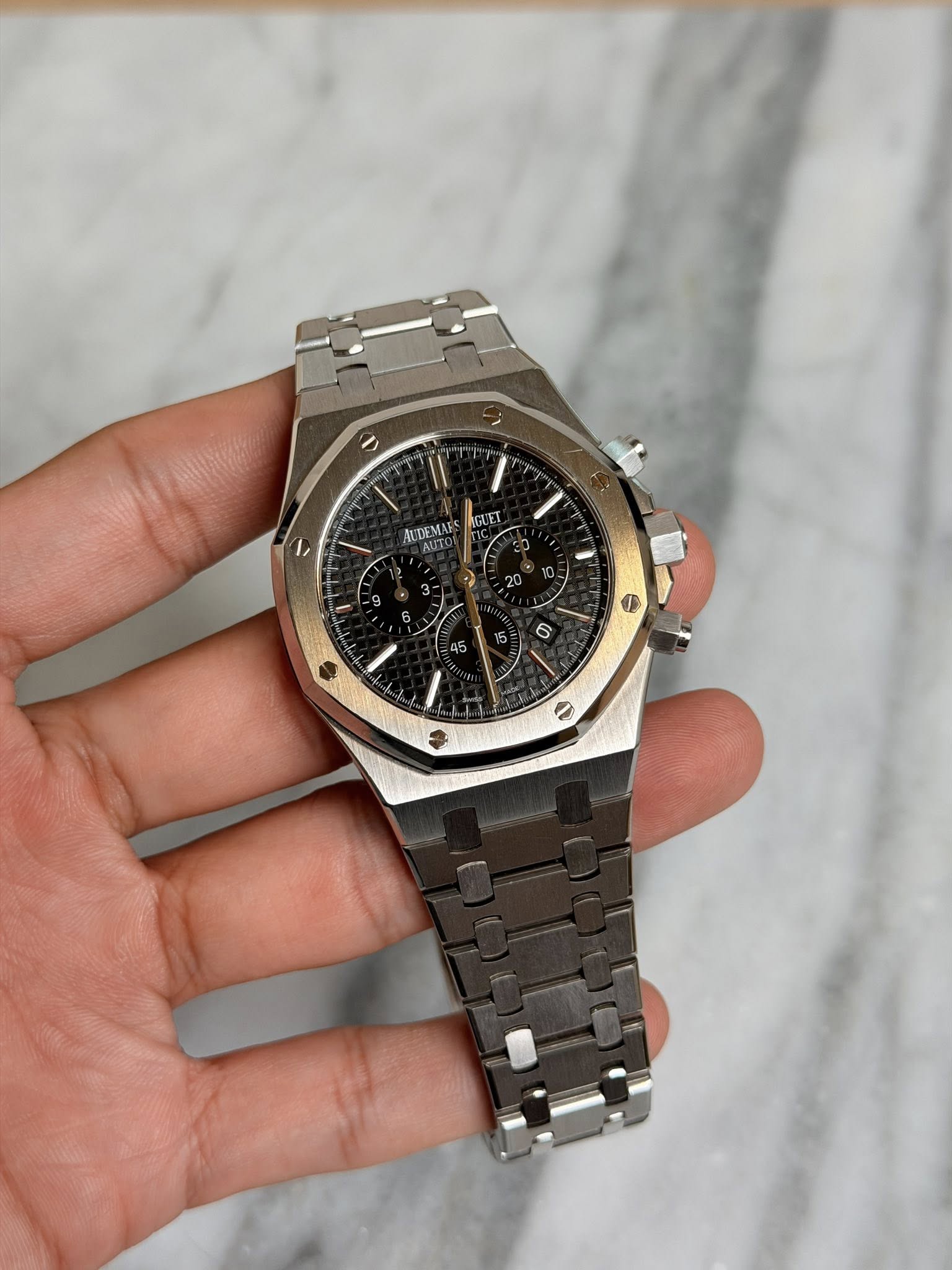 May be an image of wrist watch and text that says 'ر ۱١ II AUDEMAE AGUET 1 3- ۵ 45 6'