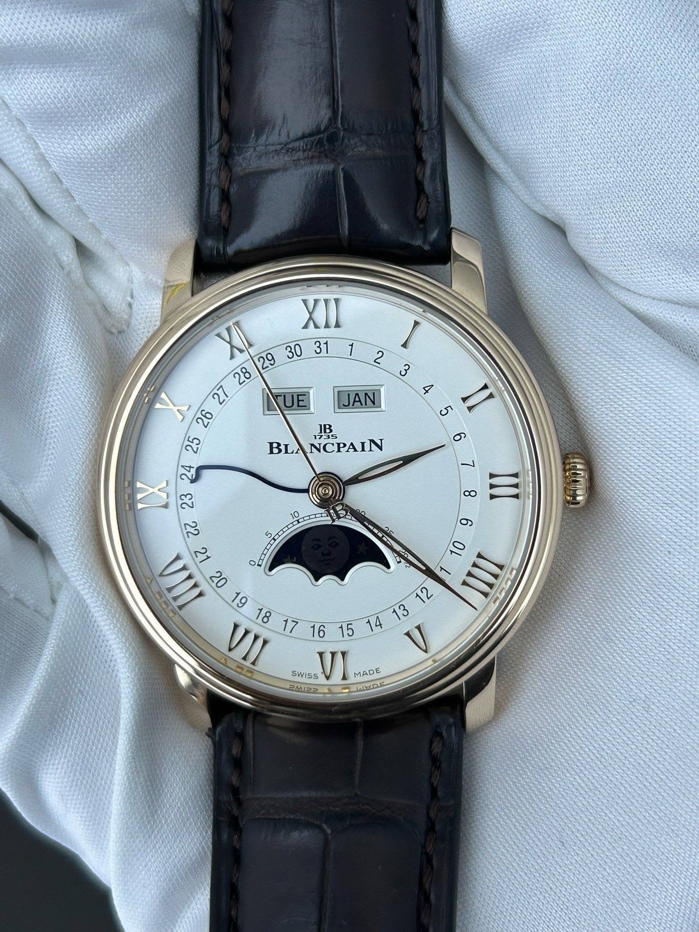 May be an image of wrist watch and text that says 'UE JAN I 2 3 4 5 II 6 7 8 III JB BLANCPAIN BLA NCPAIN XII 28 XI X IX 23 22 A 1 م مَ IIA EWISS VI عطتم AHDE MADE MADE RAAIPA بد…