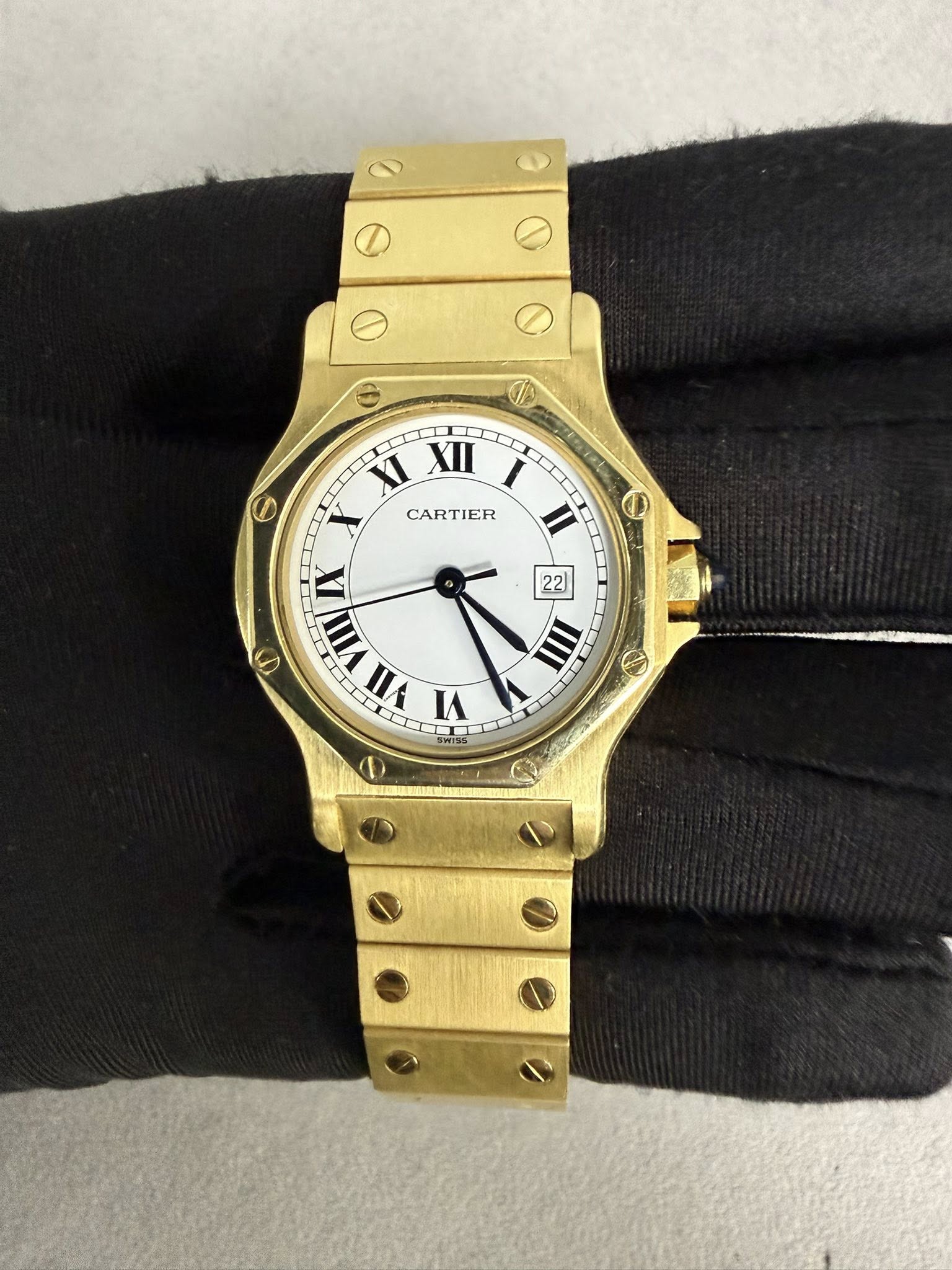 May be an image of wrist watch and text that says 'I 6 XI XII CARTIER O 22 X VIII a 0 nΑ IN 0 IIII O N'