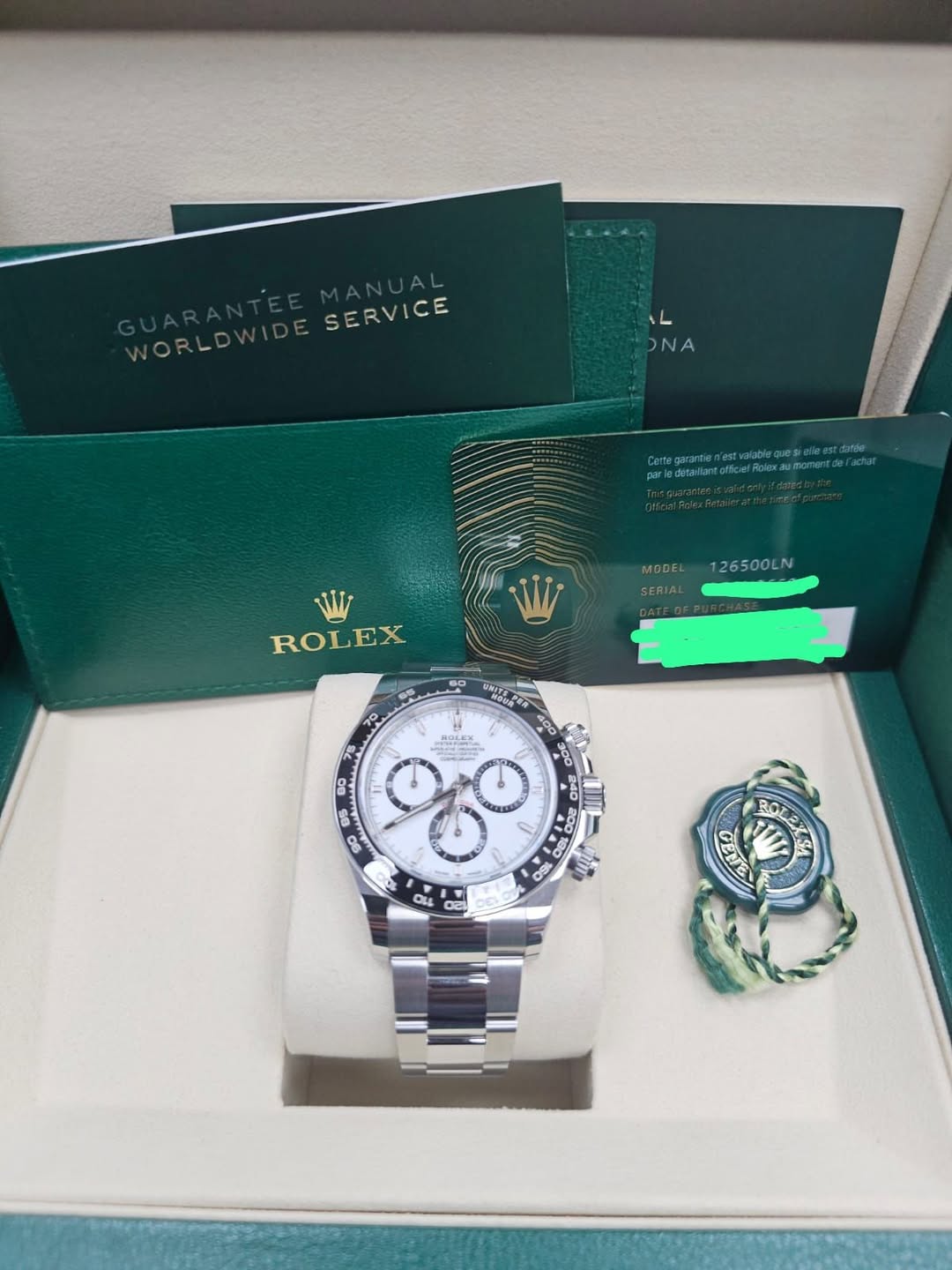 May be an image of wrist watch and text that says 'WORLD SERVICE ONA W ROLEX MODEL126500LN MODEL 126500LN SERIAL ገ0 SP BOLEX D8 2001 0S ROLEX GELE'