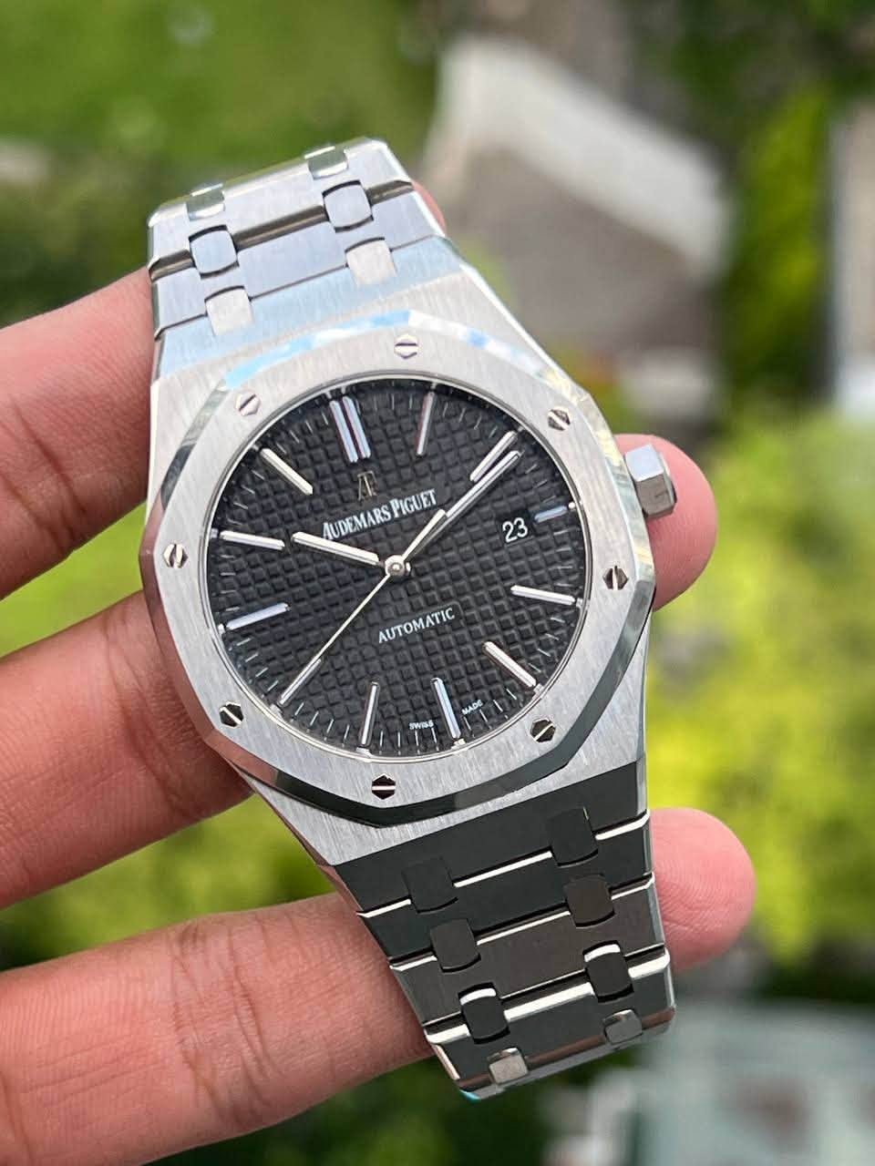 May be an image of wrist watch and text that says 'こ PIGUET IUDEMARSPIGUET P1G AUDEMA RS O 0 23 AUTOMATIC AUTOMATIC KADE sWIg'