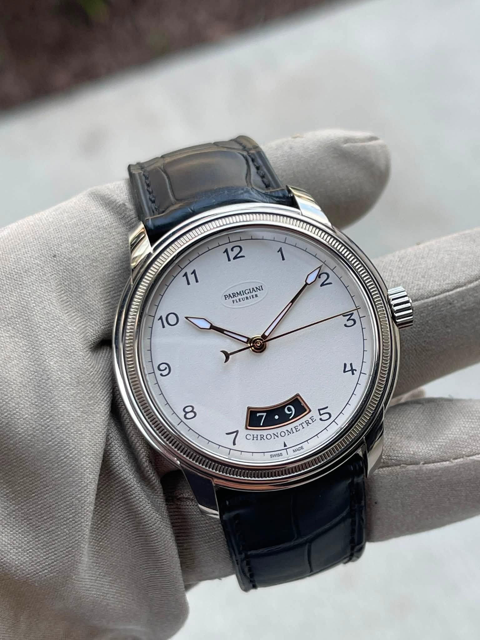 May be an image of wrist watch and text that says '12 1 11 PARMIGIANI FLE好I高 10 ጌ 3 9 七 8 5 7 CHRONOMETRE OMETRE MADE BACE WISE'