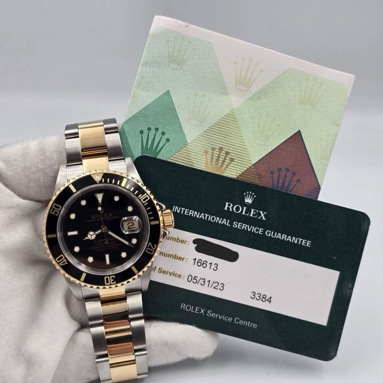 May be an image of wrist watch and text that says 'W 110 ន 40 INTERNATIONAL ROLEX SERVICE Vumber: GUARANTEE number: 16613 Service 05/31/23 1/23 ព 3384 ROL ROLEX Service Ser vice…