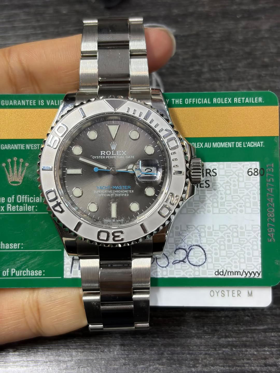 May be an image of wrist watch and text that says 'GUARANTEE IS VALIO THE OFFICIAL ROLEX RETAILER. 0 GARANTIE N'EST 50 n ေးြိ်းြ်် ROLEX LEX EX ROL OYSTER OYSTERPERPETUAI TUAI…