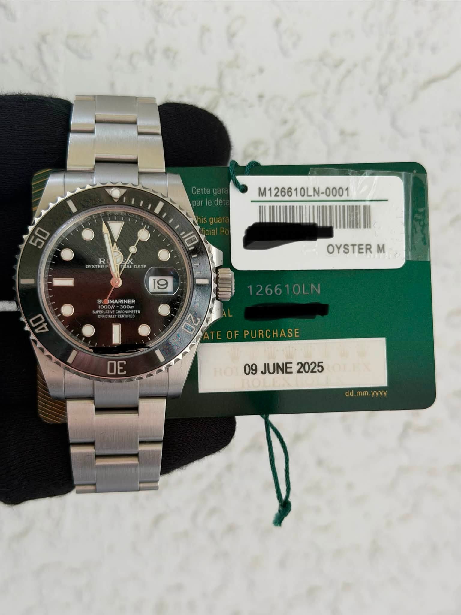 May be an image of wrist watch and text that says '50 M126610LN-0001 R 10 19 MARINER OYSTERM M 40 26610LN 20 DE 09 JUNE 2025 JUNE2025 OLT dd.mm.y m.yyyy'