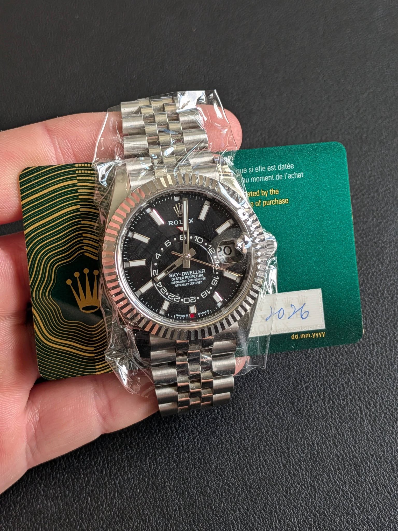 May be an image of wrist watch and text that says 'bm V eile est datée ลน momentd de l'achat ated db by the of purchase RO O X ES 6 10 4 SKY- a en ጋብ こちき島品を 1026 dd.mm.yyYy dd.…