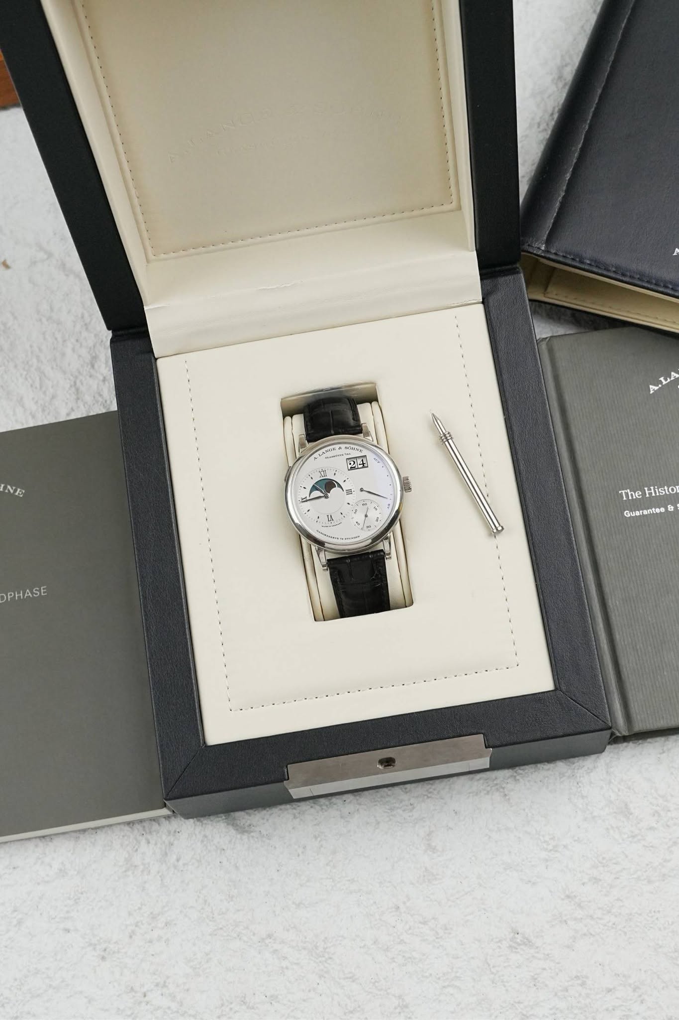 May be an image of wrist watch and text that says 'NE ای A.LA ניבוה TA PHASE The Histor Guarantes'
