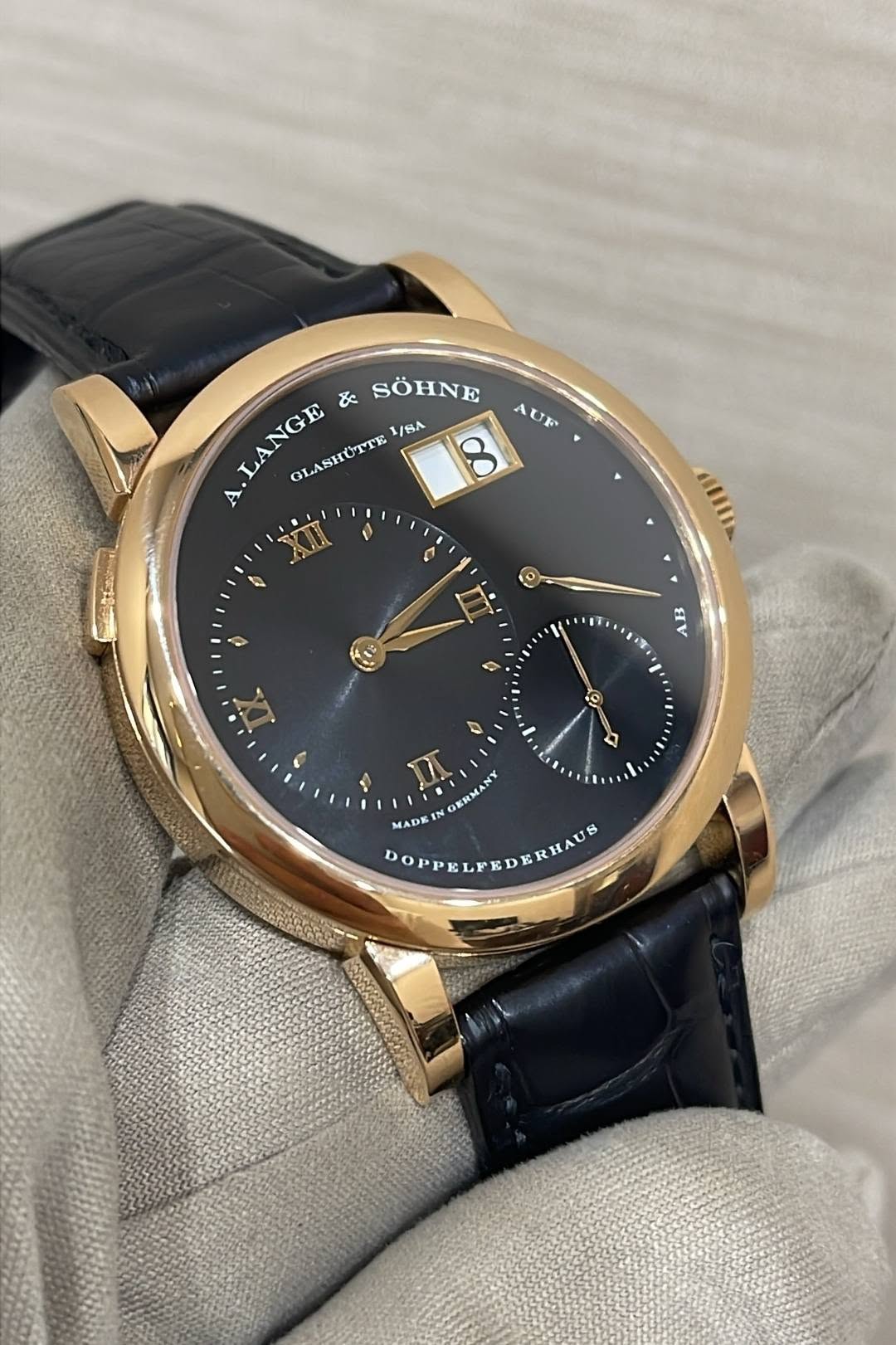 May be an image of wrist watch and text that says 'LANGE & SÖHNE 1/SA OLASHUTTE A AUR CBIlIA 6 EV O ১ - MADE DOPPELPEDERHAUS MAD IN GERMANY D HAUS'