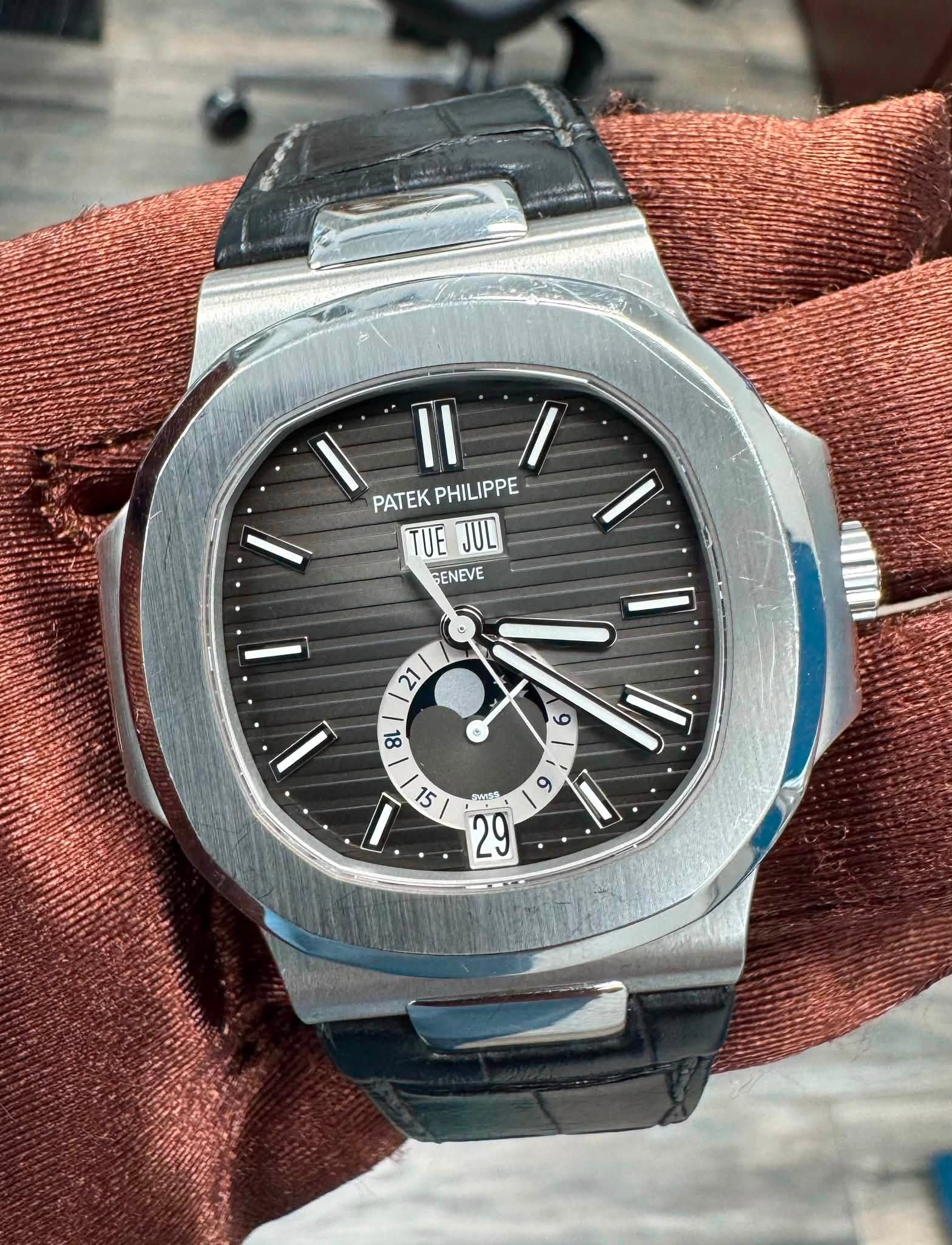 May be an image of wrist watch and text that says '١ II PATEK PHILIPPE PATEKPHILIPPE PHIL TUEJUL TUE JUC SENEVE ١ 21 86 ® و ١ 6 9 I 15 SWISE م'