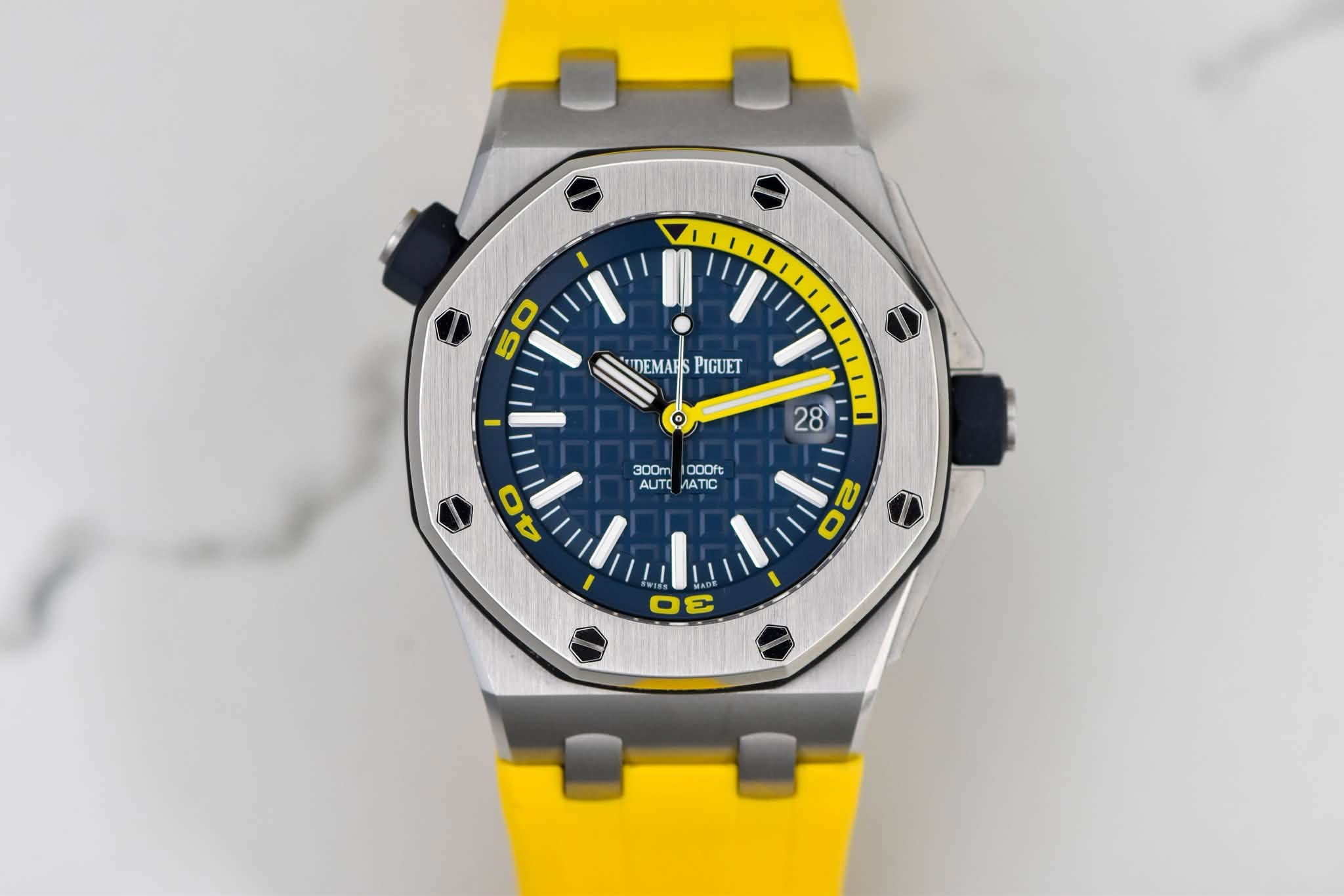 May be an image of wrist watch and text that says '5 50 O DEMAHPIGUET DEMARS PIGUET 28 300m 1000ft AUTO AT 30c/00 TIC O ויי C σε'