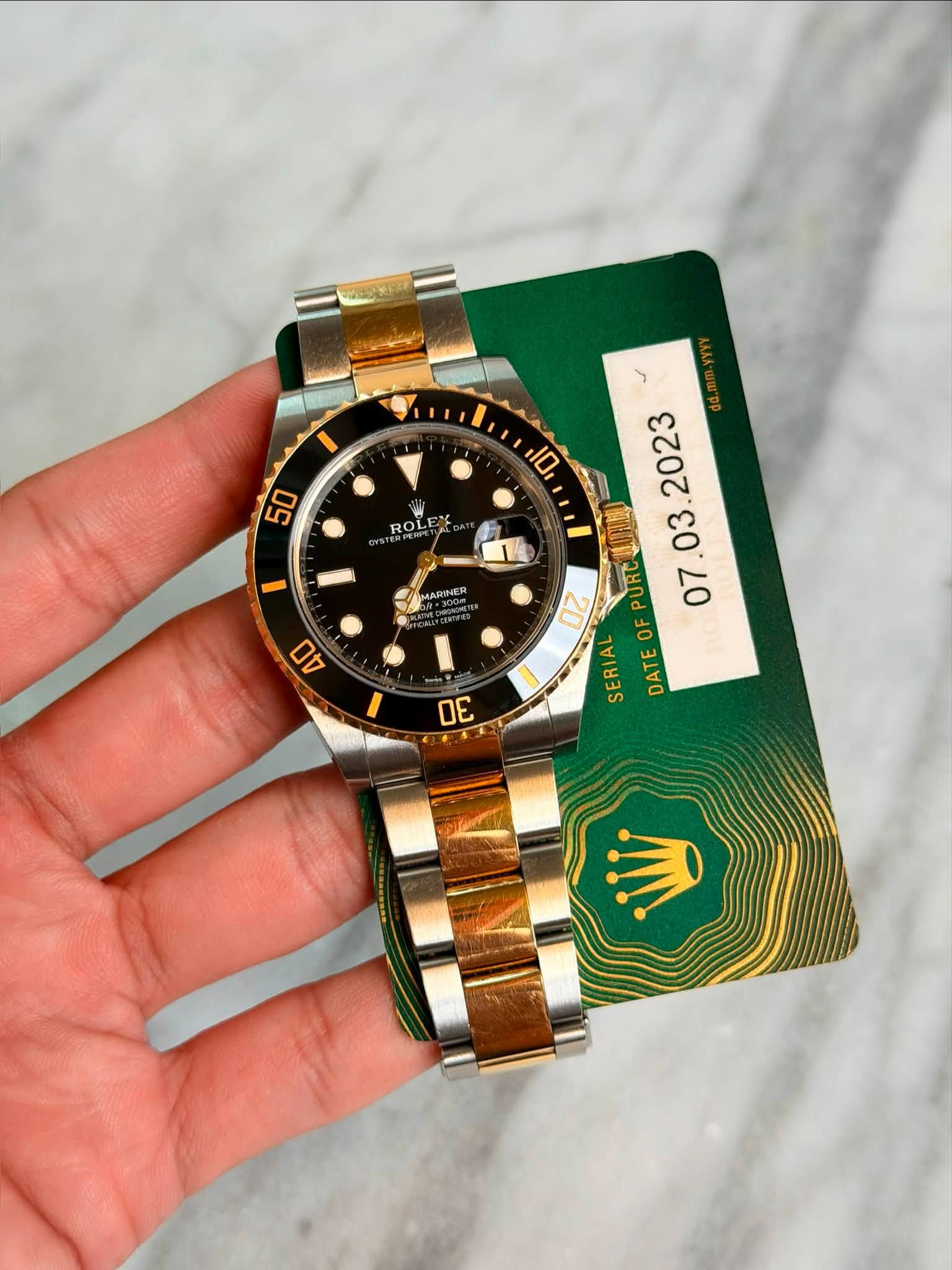 May be an image of wrist watch and text that says '50 ROL লবজশ MARINER ٢ e DATEOFPURCAUNN 00 PURC OF SERIAL DATE 40 0E'