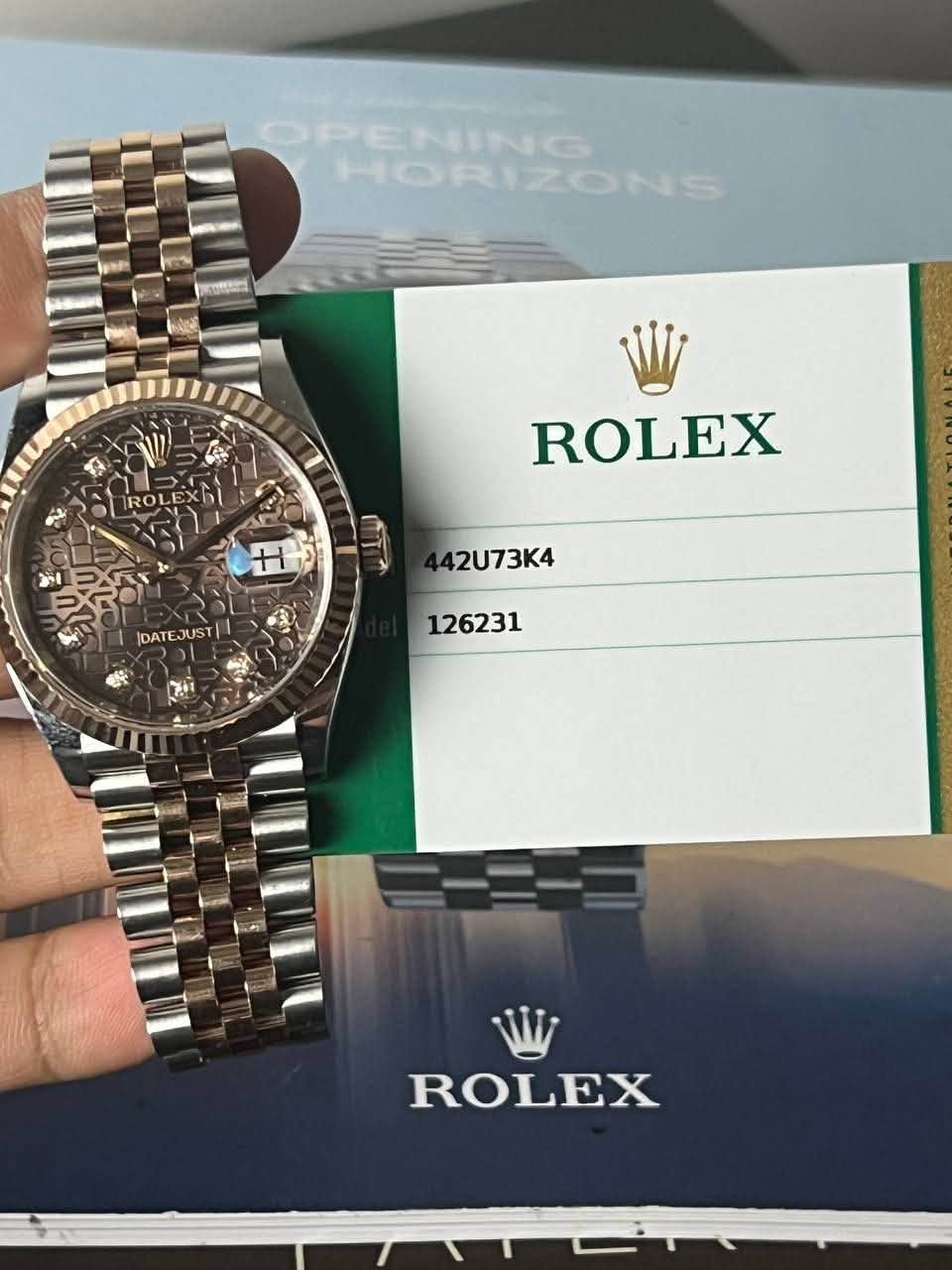 May be an image of wrist watch and text that says 'HORIZONS HORI 1 ROLEX H H DATEJUST JUST |DATE 42U73K4 126231 ROLEX'