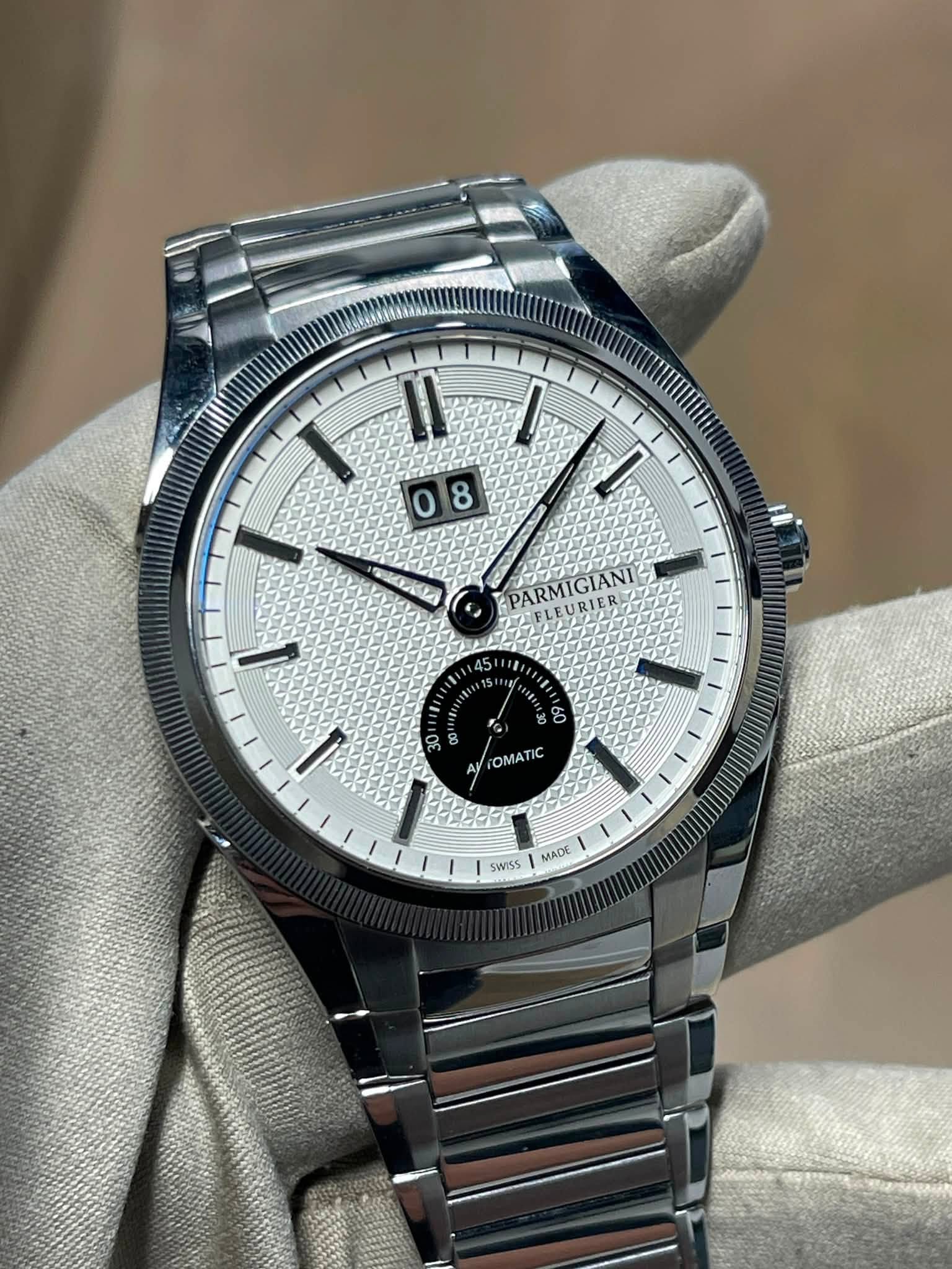 May be an image of wrist watch and text that says '08 MOXEA PARMIGIANI 07777-47 ELEURIER 45 SE b と 0 20 A OMATI SWISS I MADE'