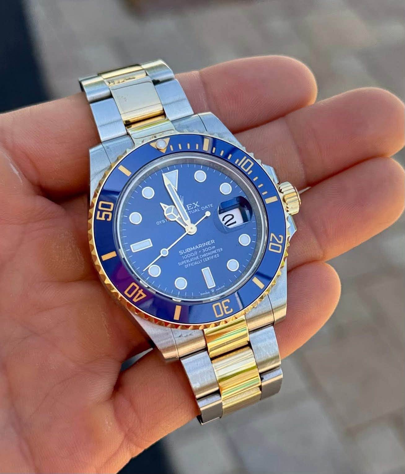 May be an image of wrist watch and text that says '10 50 OYS EX TUAL UAL DATE ጵያ α SUBMA SUBMARINER 300m OT CERTERA CERTE 10000 NA 1000/ PEUCIRA PEOLAINEG SUPERLAS OFFICIALL 20 AO…