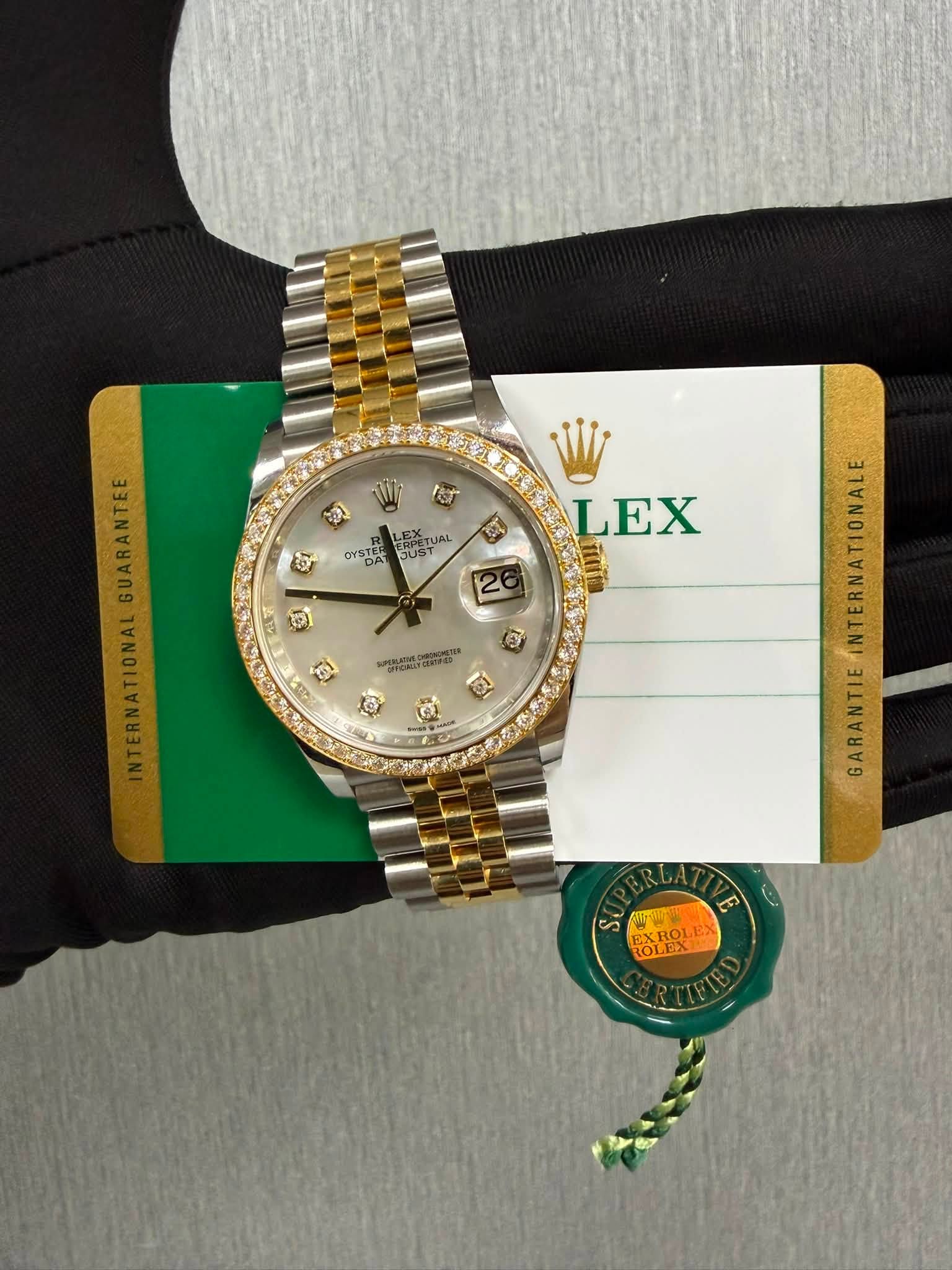 May be an image of wrist watch and text that says 'גכמל LEX 数 CYSTE OYSTER YDA JUST פי LEX o 26 G MSEE INTERNATIONALGUARANTEE GARANTIE ه A സീതതം EXT OLEX EXROLI KROL'