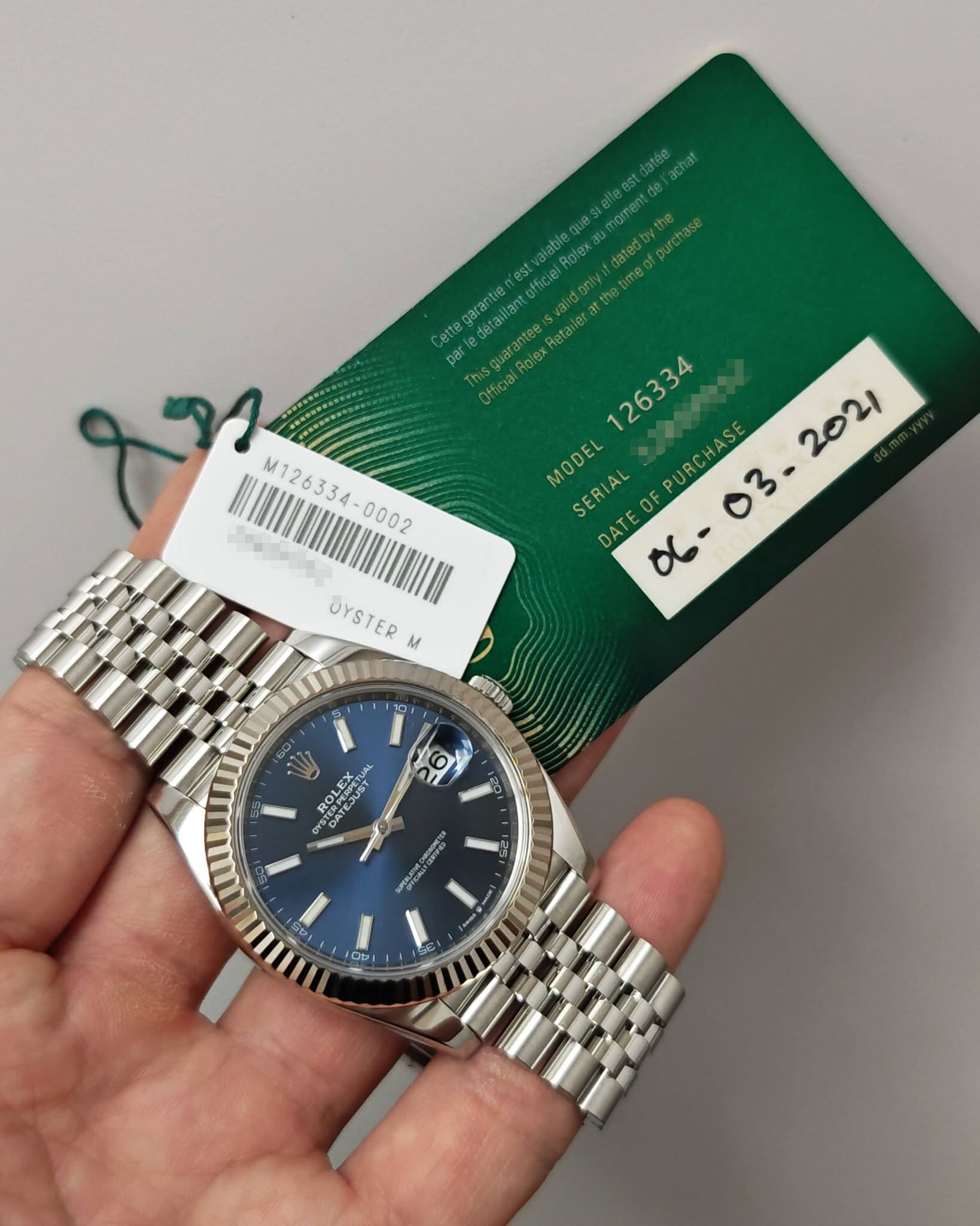 May be an image of wrist watch and text that says 'atée Rolex fpurchase egarantie Cette par etai Official Rolex Dlex Ofticia M126334 M126334- MODEL SERIAL F P URCHASE DATE ፅቤ…