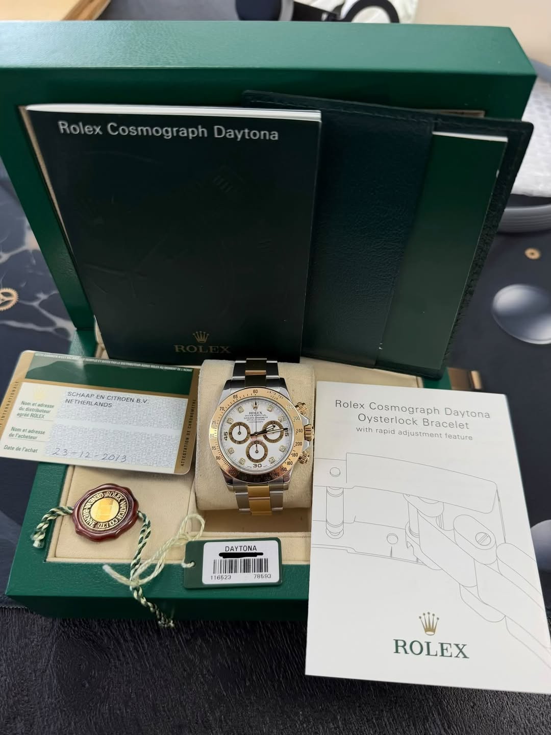 May be an image of wrist watch and text that says 'RolexCosmographDaytona Rolex Cosmograph Daytona SCHAAP N 1DE MOE THOENG V. ค- ФeЛиaиBblT Лprraewлиe 마고라 Dave Pacbur 23:- ه…
