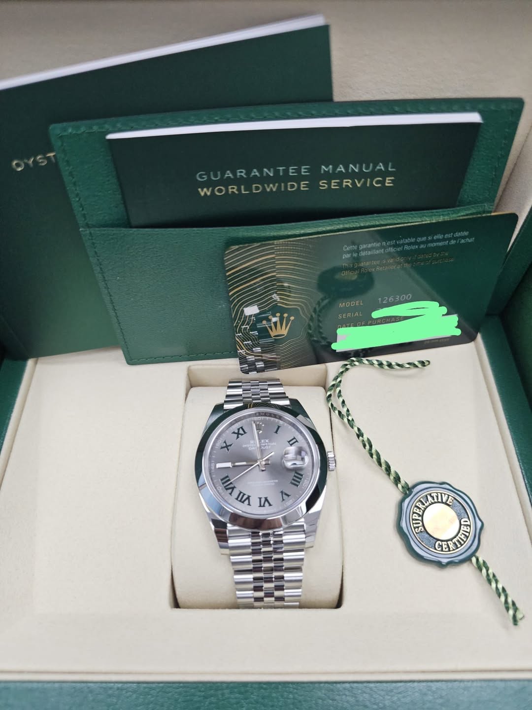May be an image of wrist watch and text that says 'GUARANTEEMANUAL GUARANTEE MANUAL WORLDWIDE WORLDWIDESERVICE DE SERVICE SER MOPE! SERIA 126300 XI ወኒ፡ عم II VIII II د 1 ۳ نAاS…