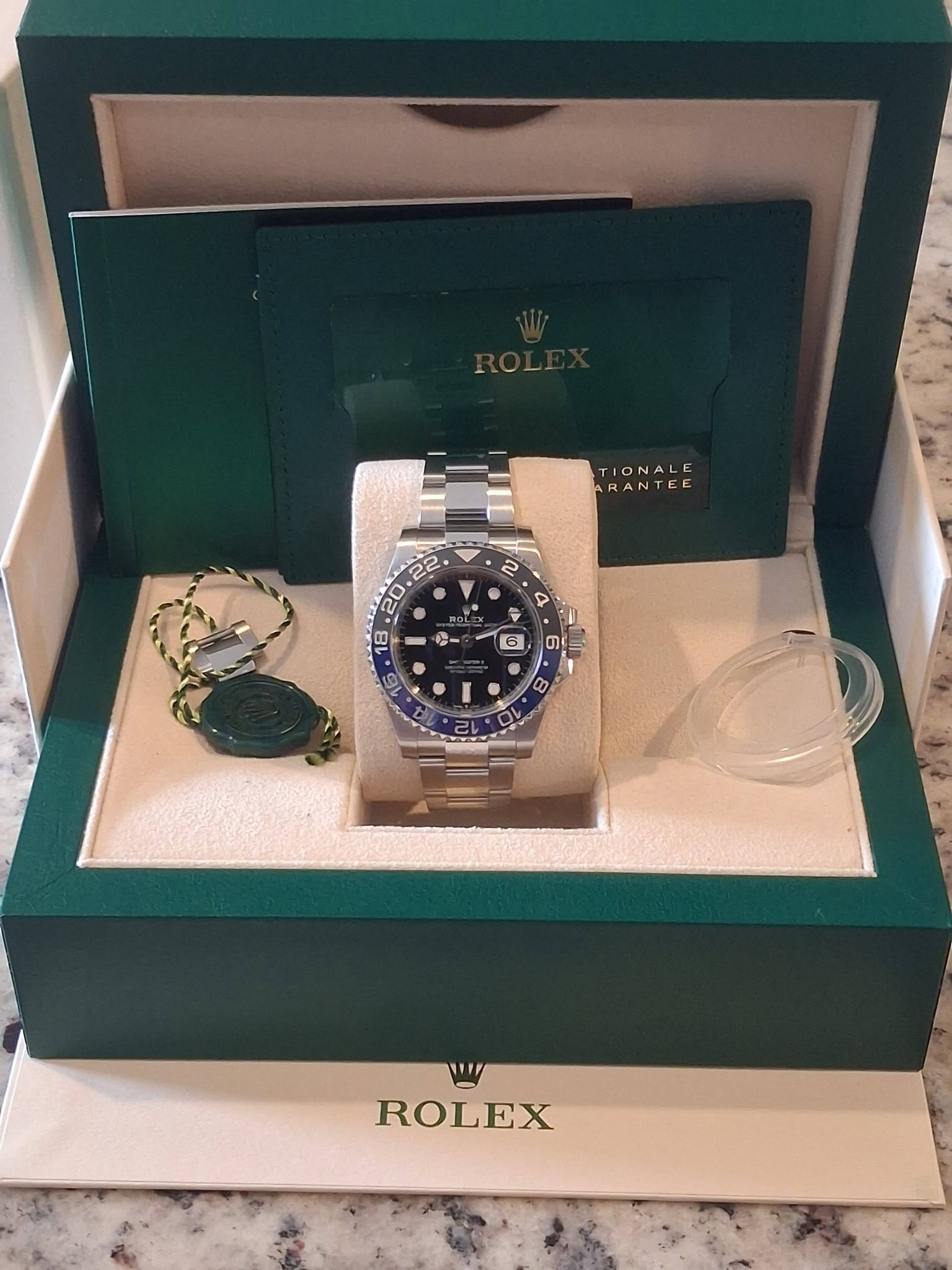 May be an image of wrist watch and text that says 'TIONALE ARANTEE 2 / oL OLE 0 xX ៣ 8 Th ROLEX'